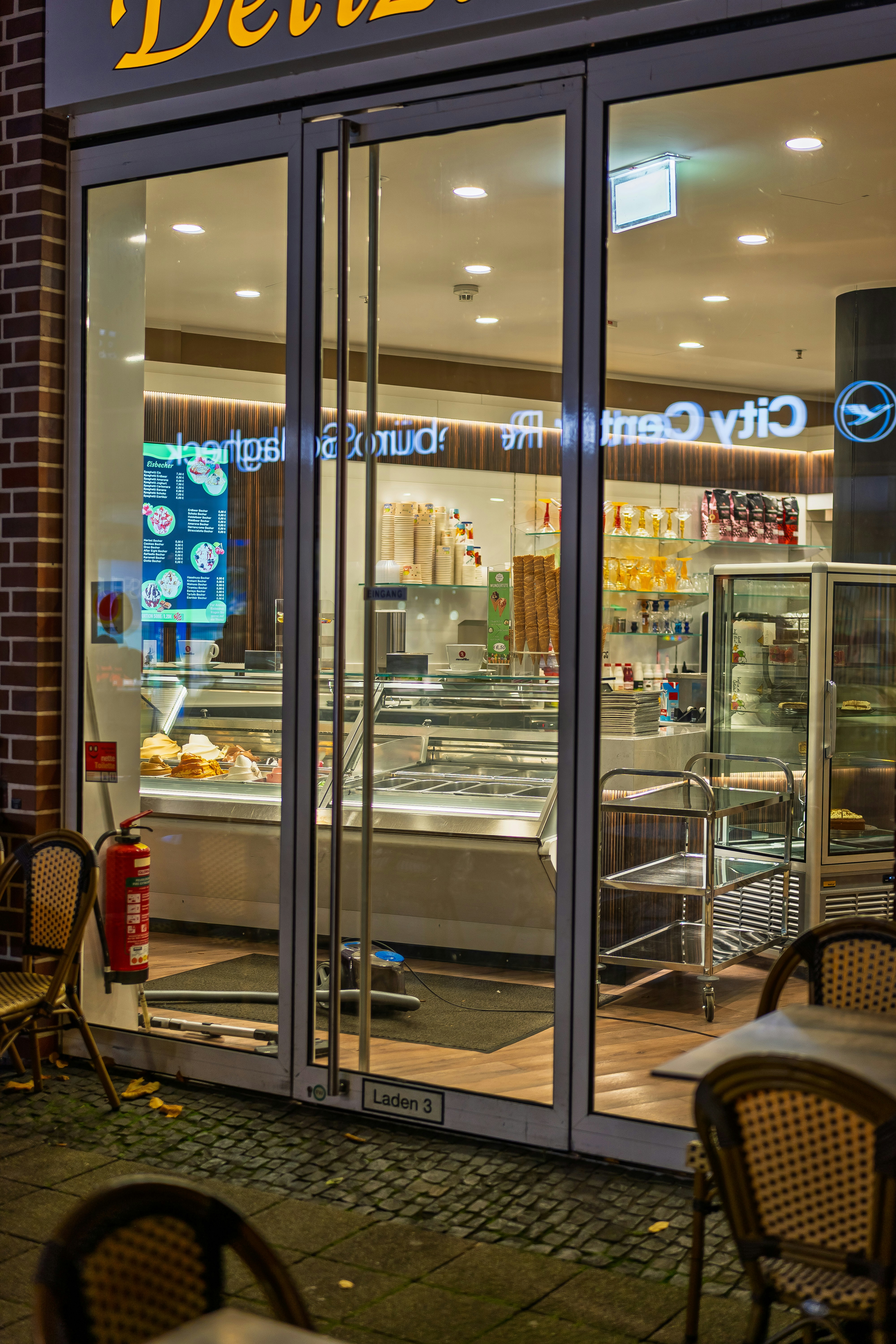 Exterior of a brightly lit ice cream shop at night.