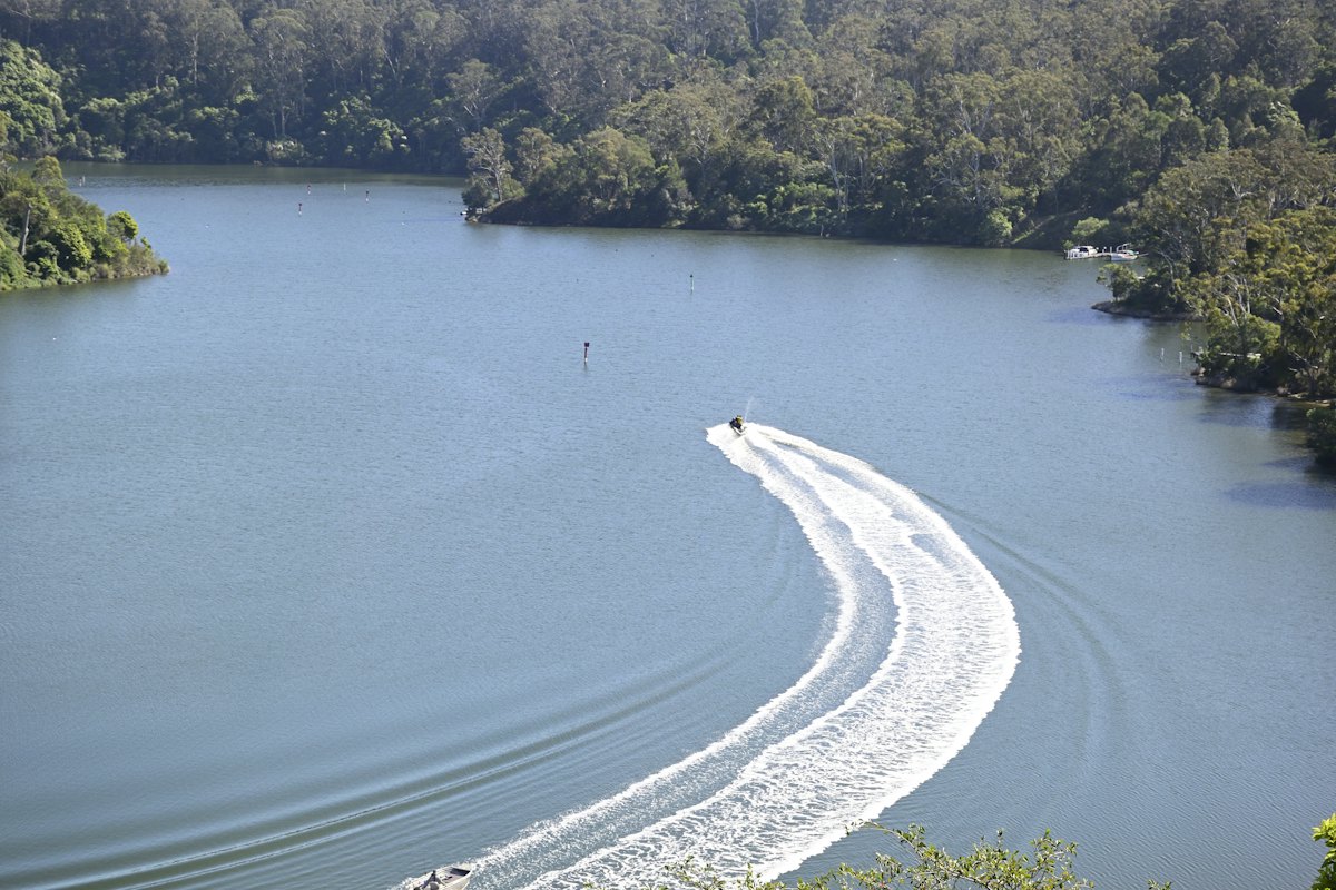 A jet ski wake curving across a lake