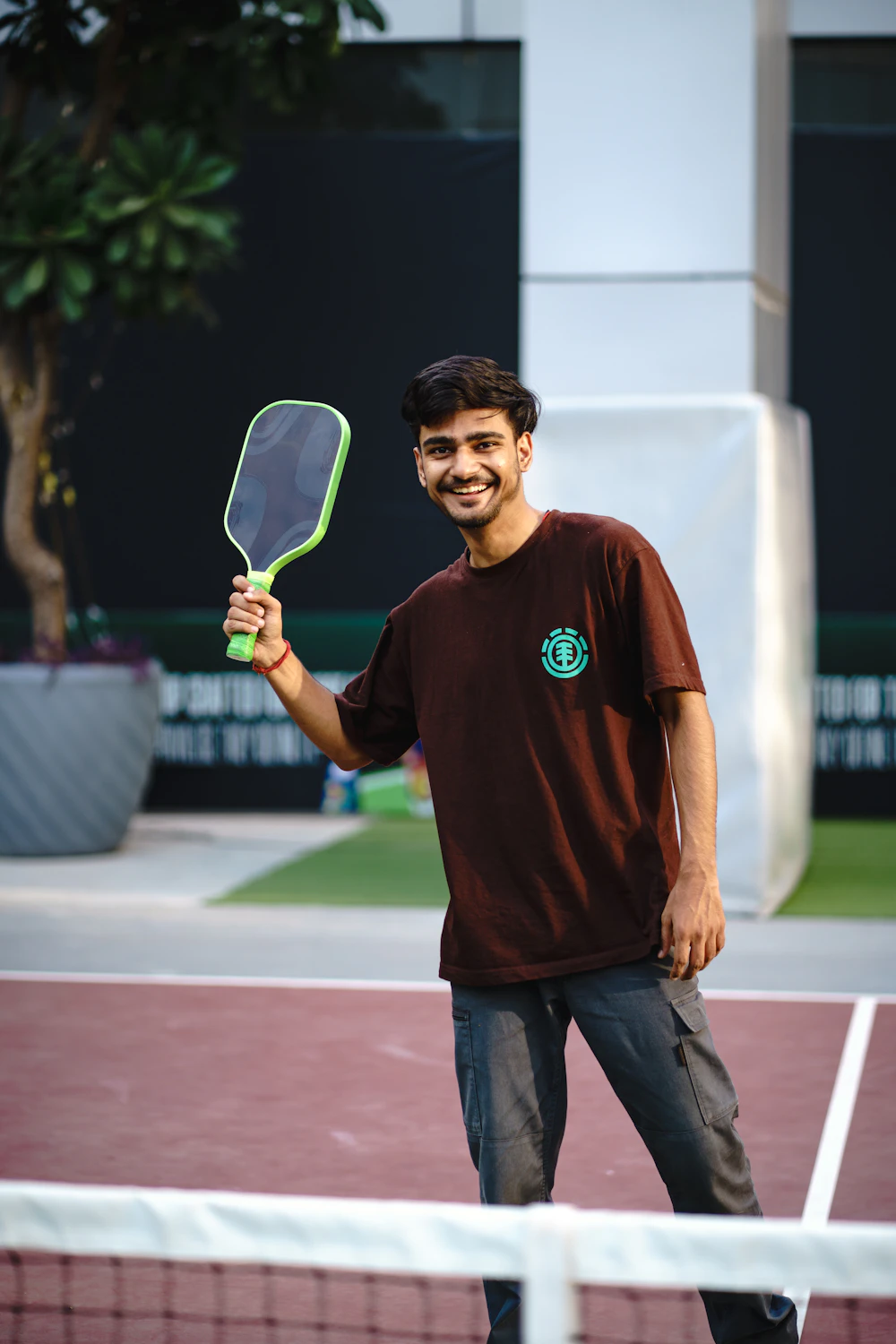 Smiling player holding a lime-green pickleball paddle