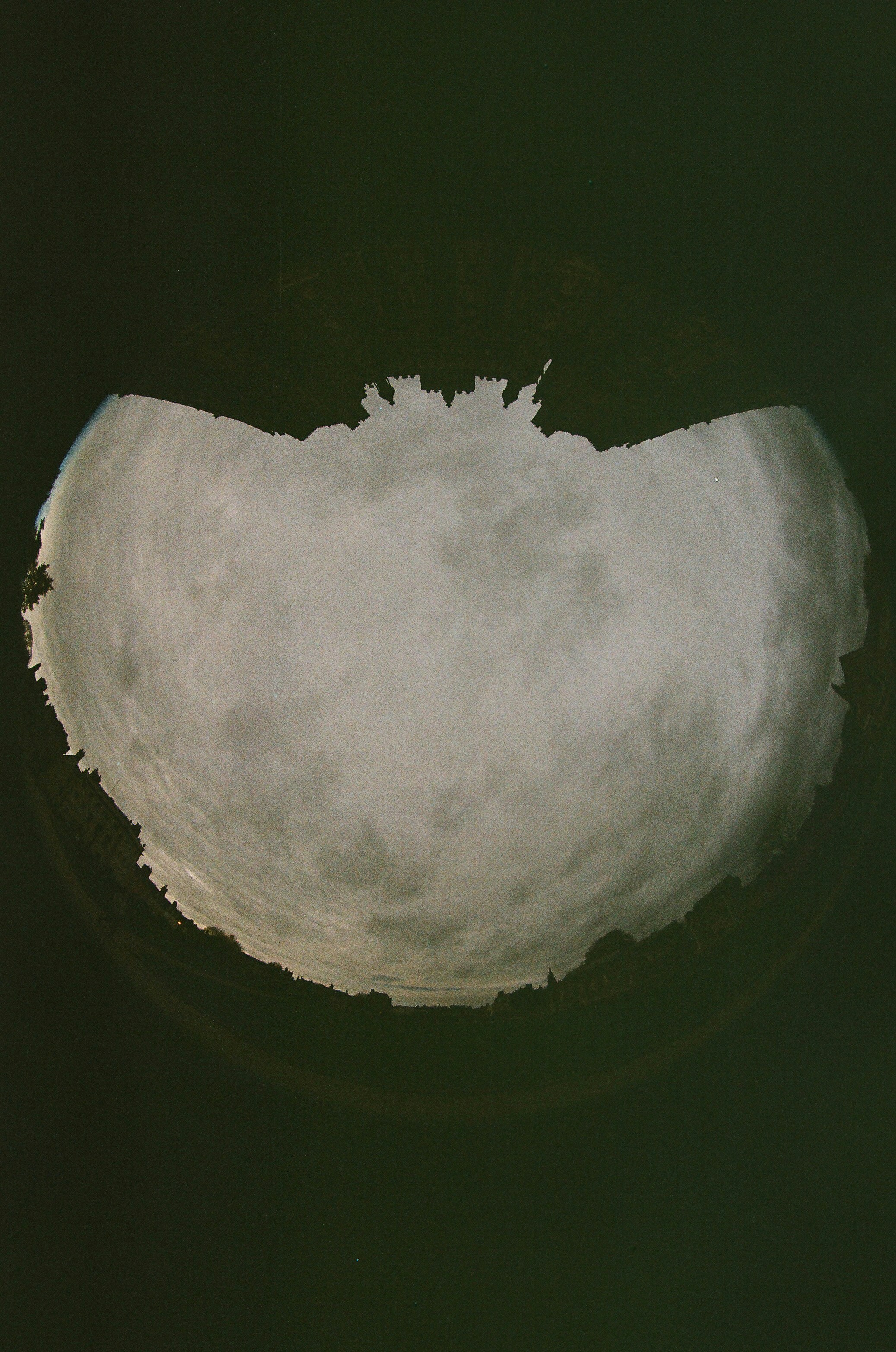 Cielo con nuvole visto attraverso un'apertura circolare scura