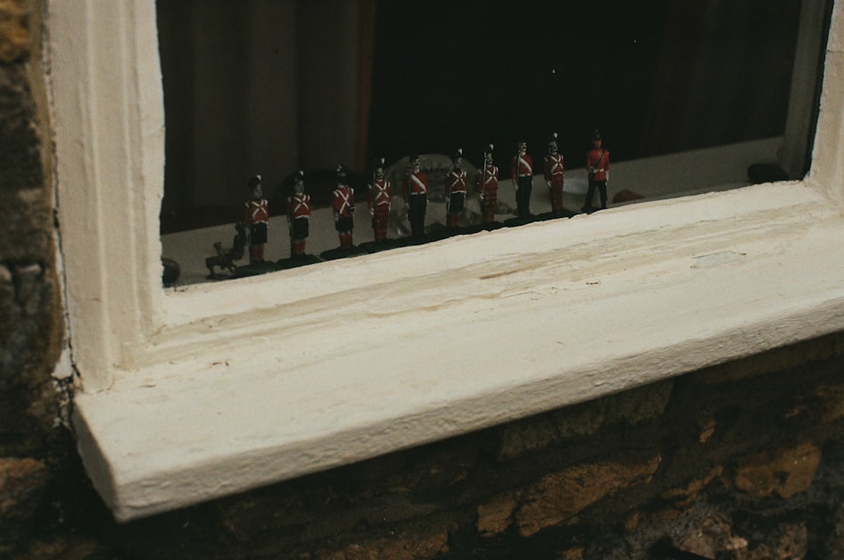Toy soldiers lined up on a windowsill.