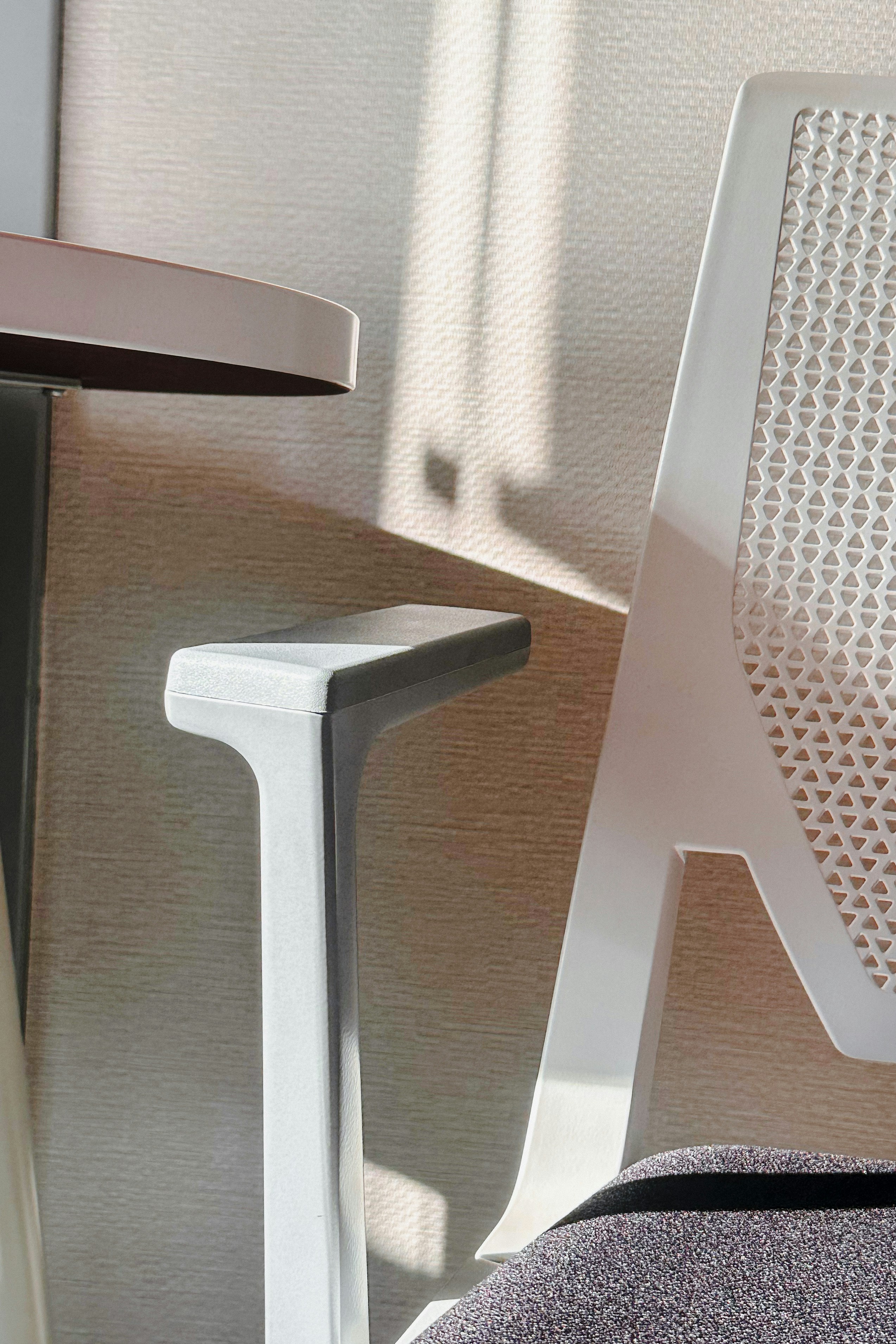 Sunlight streams onto a white modern chair