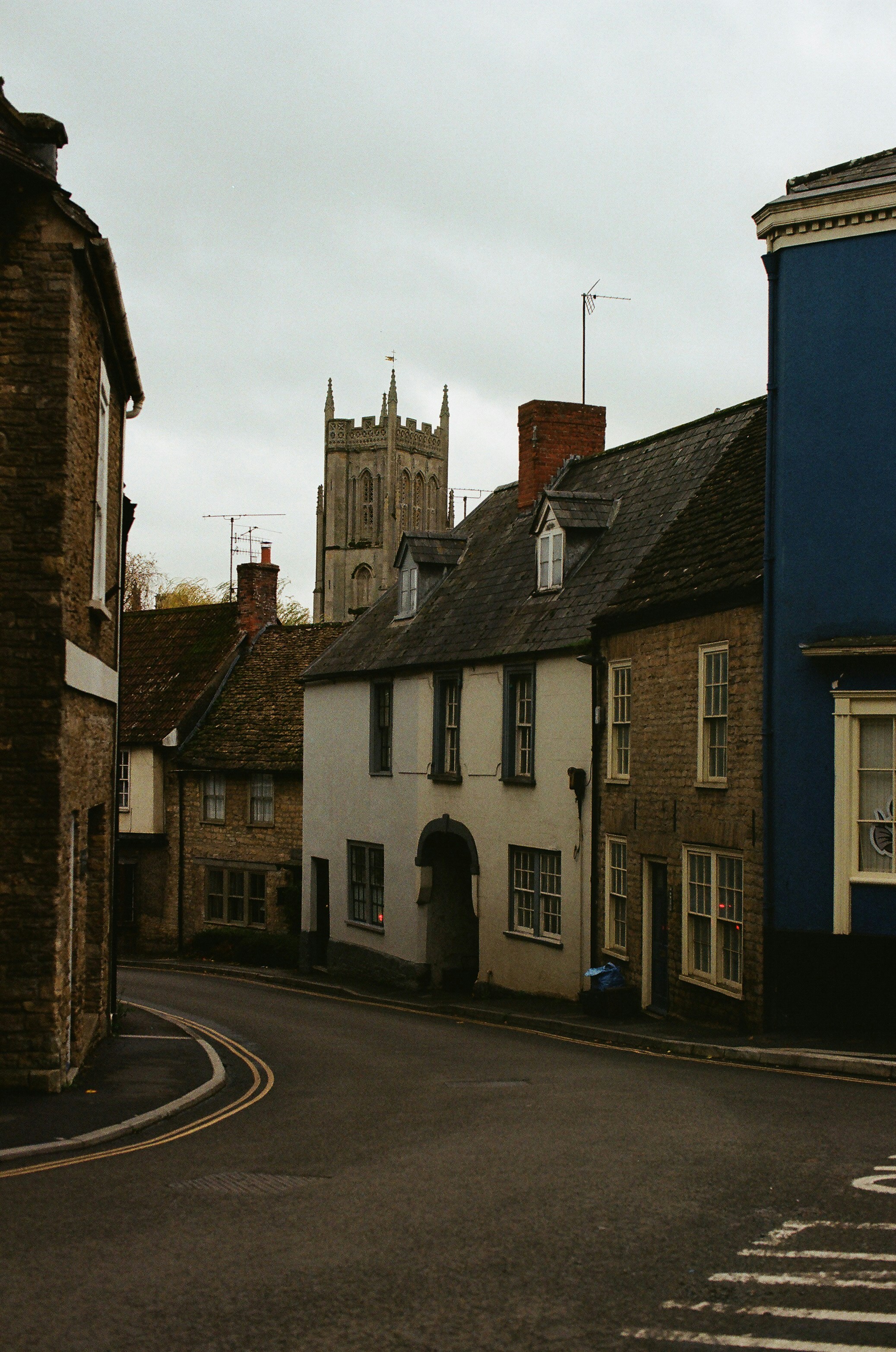 Old street with historic buildings and a church tower.