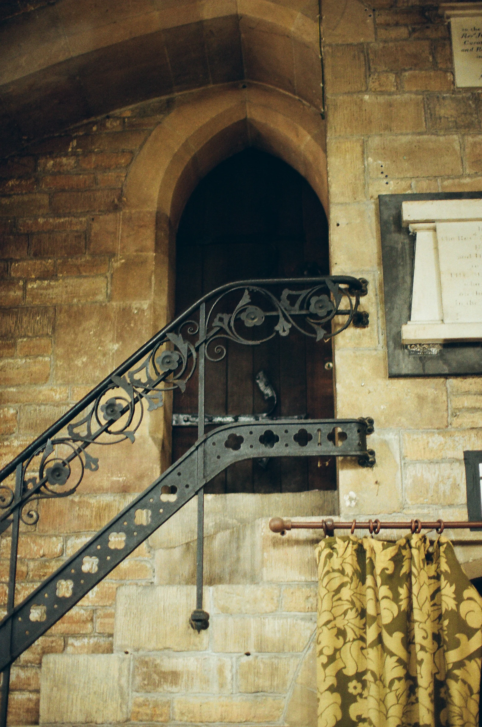 Garde-corps métallique noir à barreaudage vertical le long d'un escalier extérieur en pierre