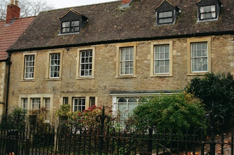 Old stone building with dormer windows and trees