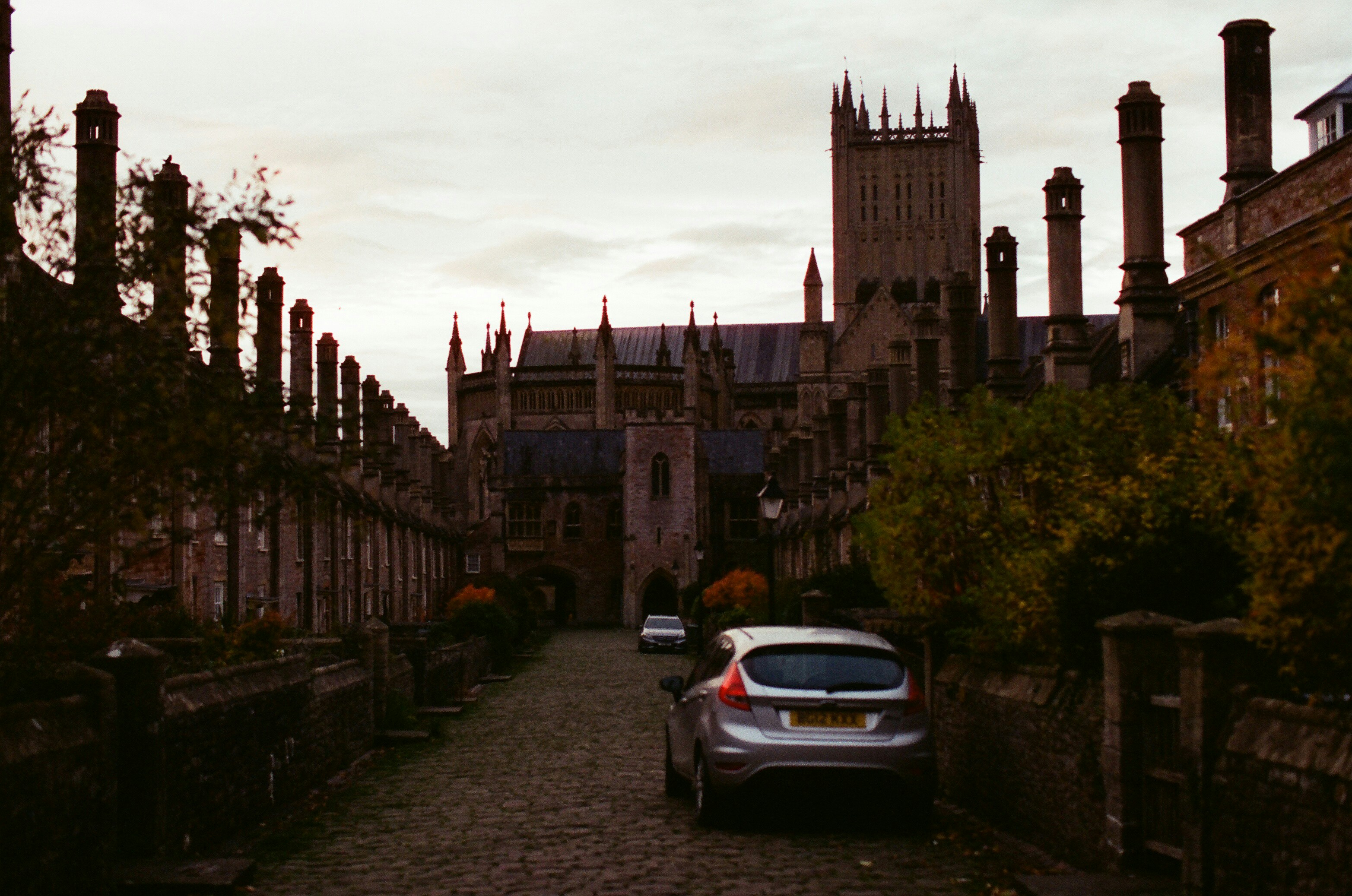 Cars parked on cobblestone path leading to cathedral