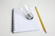 Light bulb and pencil on notepad