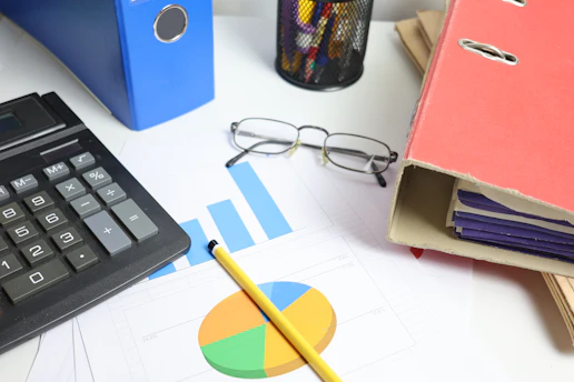 Desk with calculator, charts, and binders