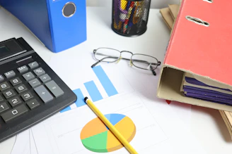 Desk with calculator, charts, and binders
