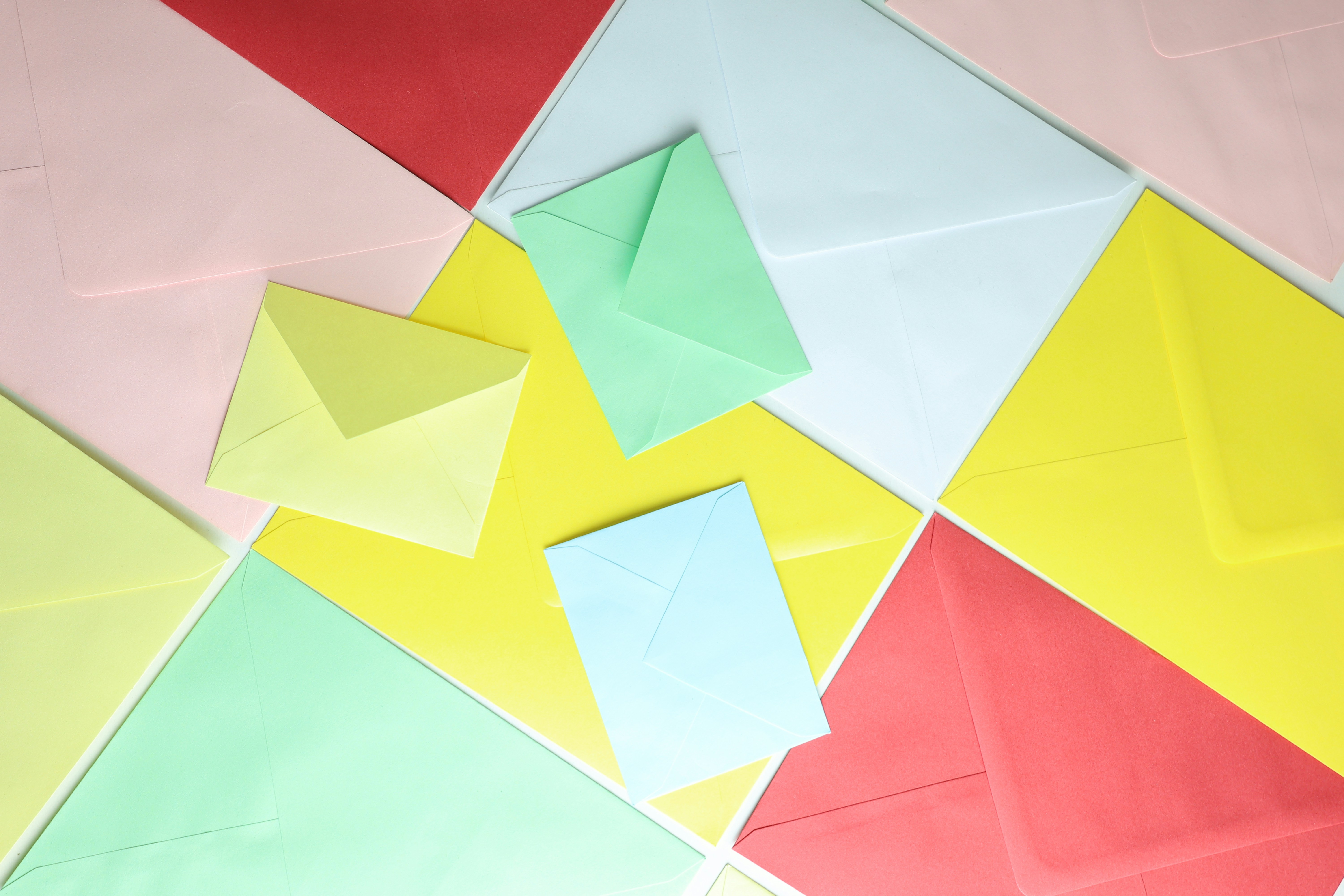 Colorful envelopes arranged in a scattered pattern.