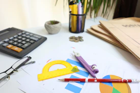 Desk with calculator, glasses, and drawing tools