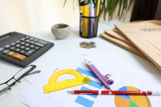 Desk with calculator, glasses, and drawing tools