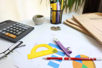 Desk with calculator, glasses, and drawing tools