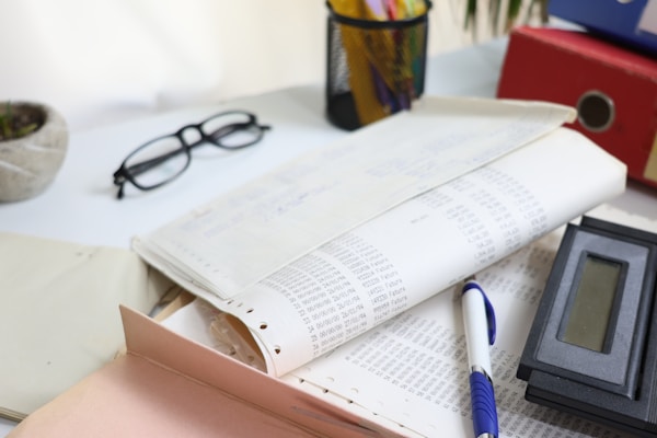 Desk with papers, glasses, calculator, and office supplies