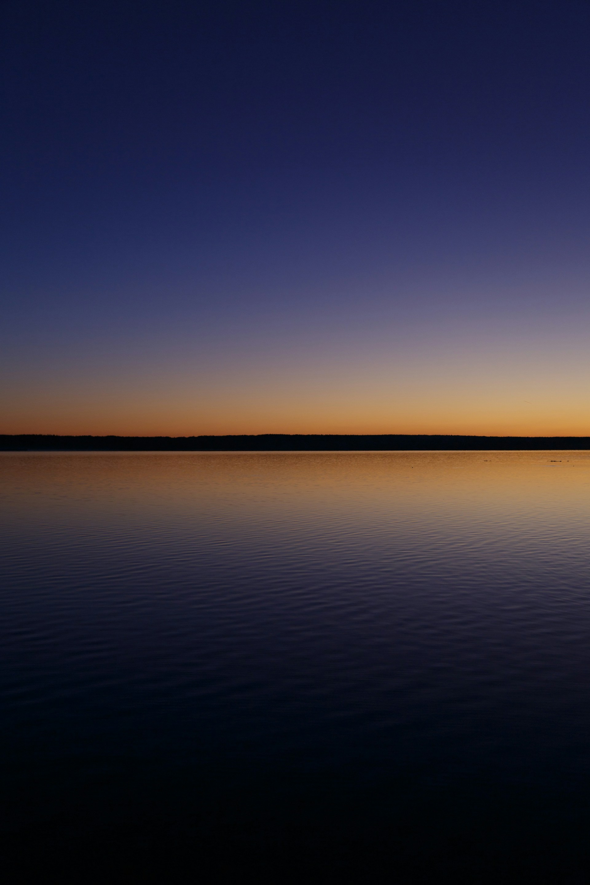Calm lake reflecting a vibrant sunset sky