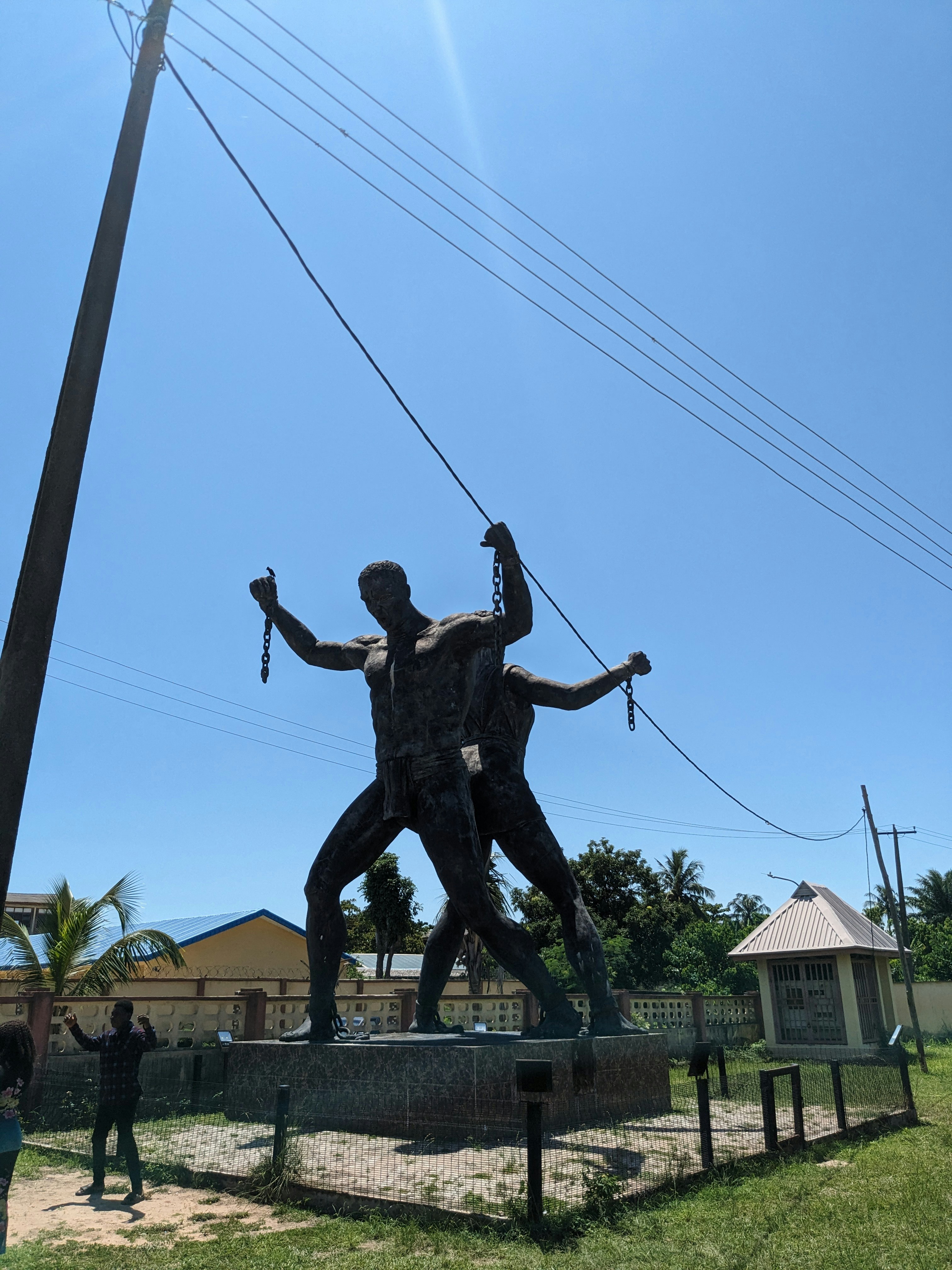 晴れた空の下で鎖を切る二人の男の像