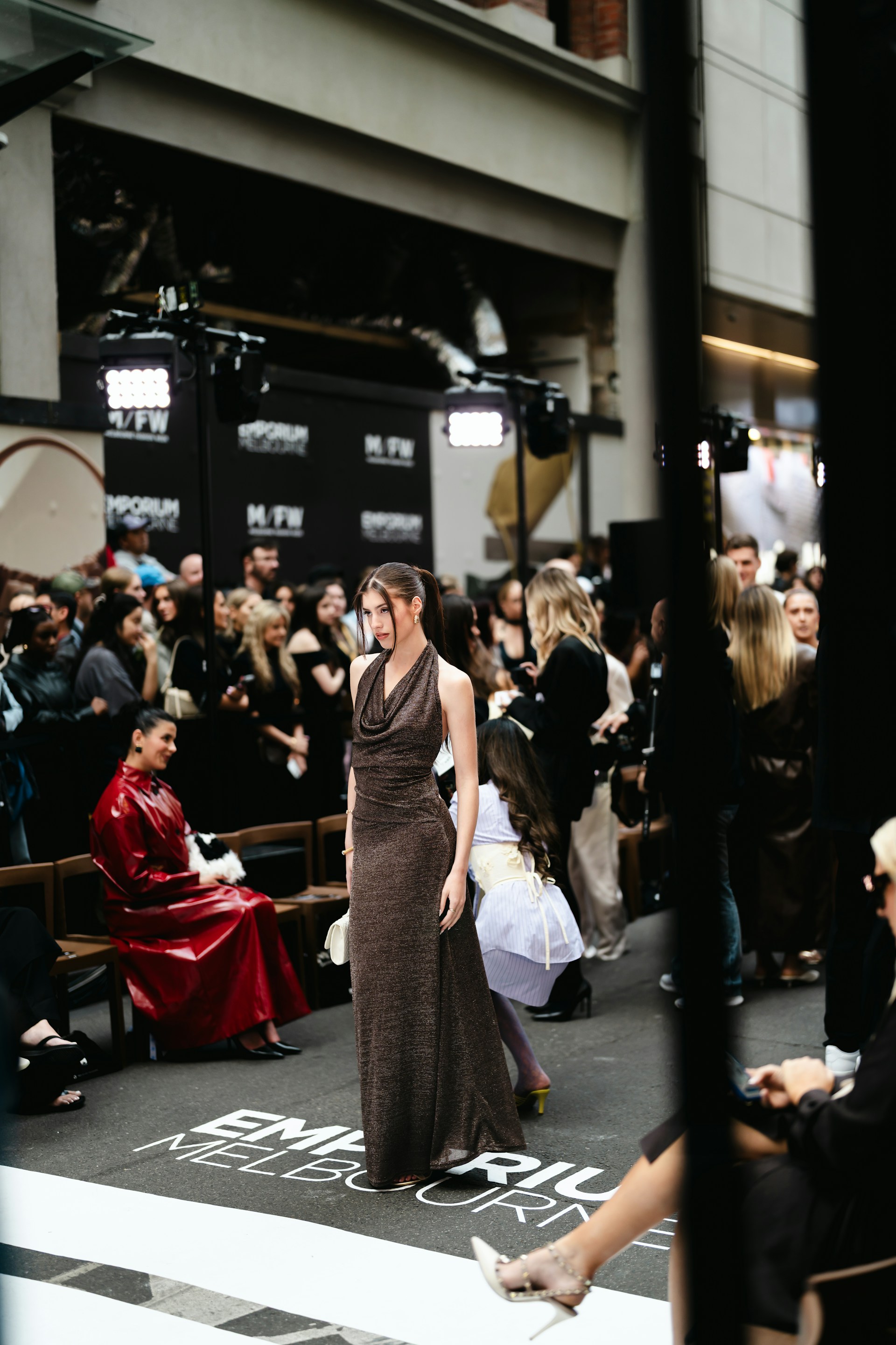 Model walks runway at fashion show event.