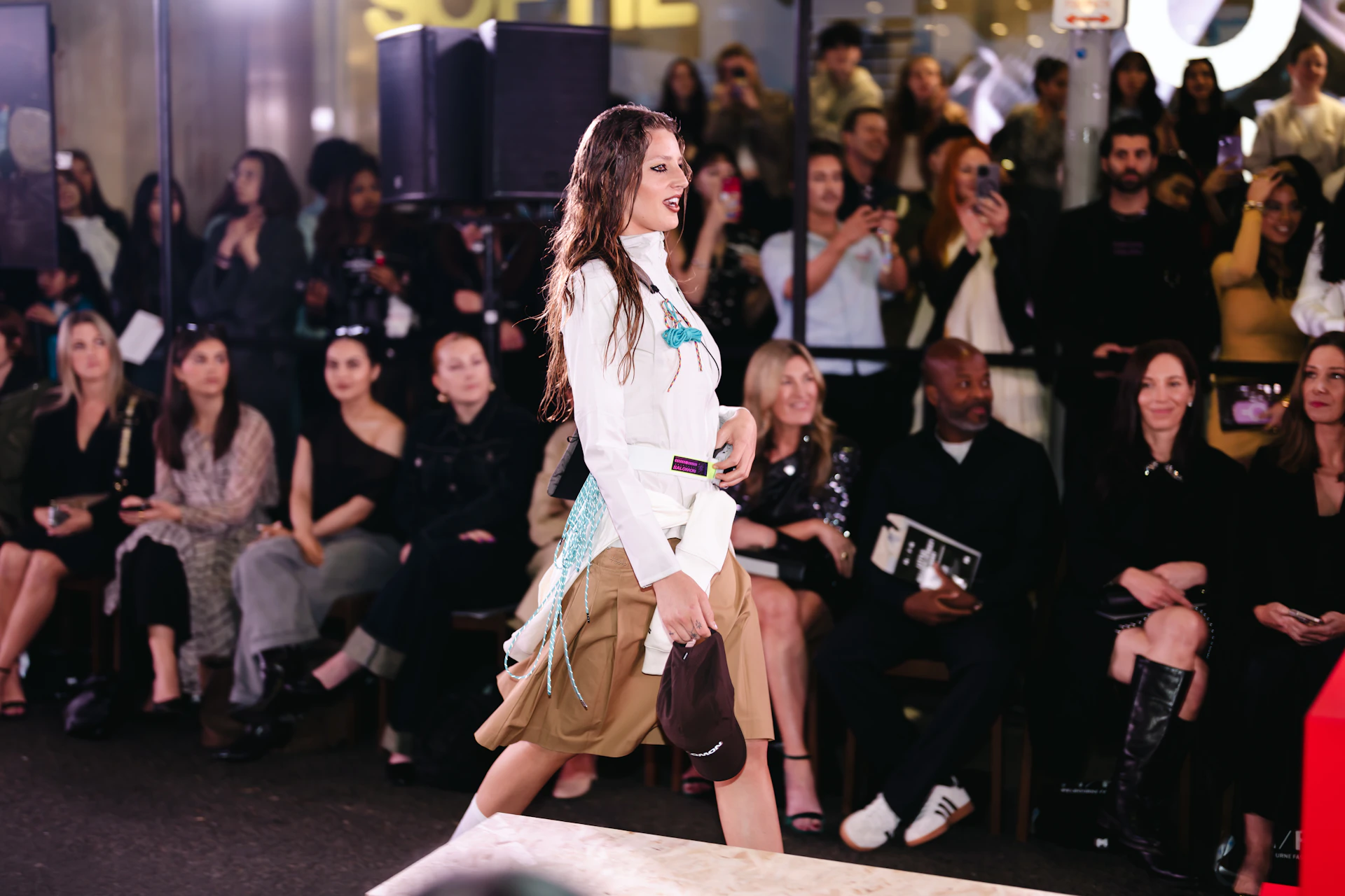 Model walks runway with audience watching
