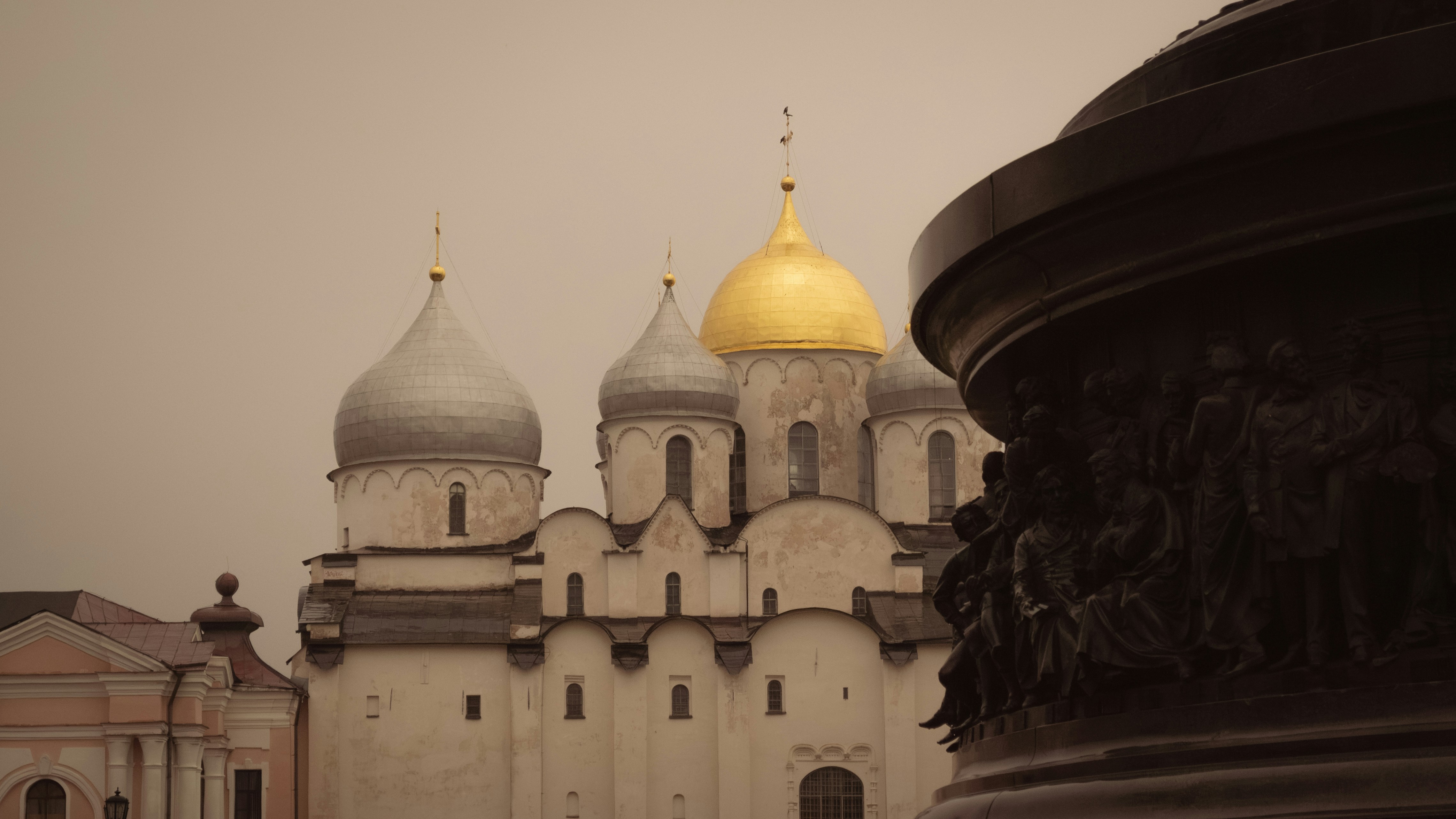 Golden domed cathedral with ornate monument in foreground