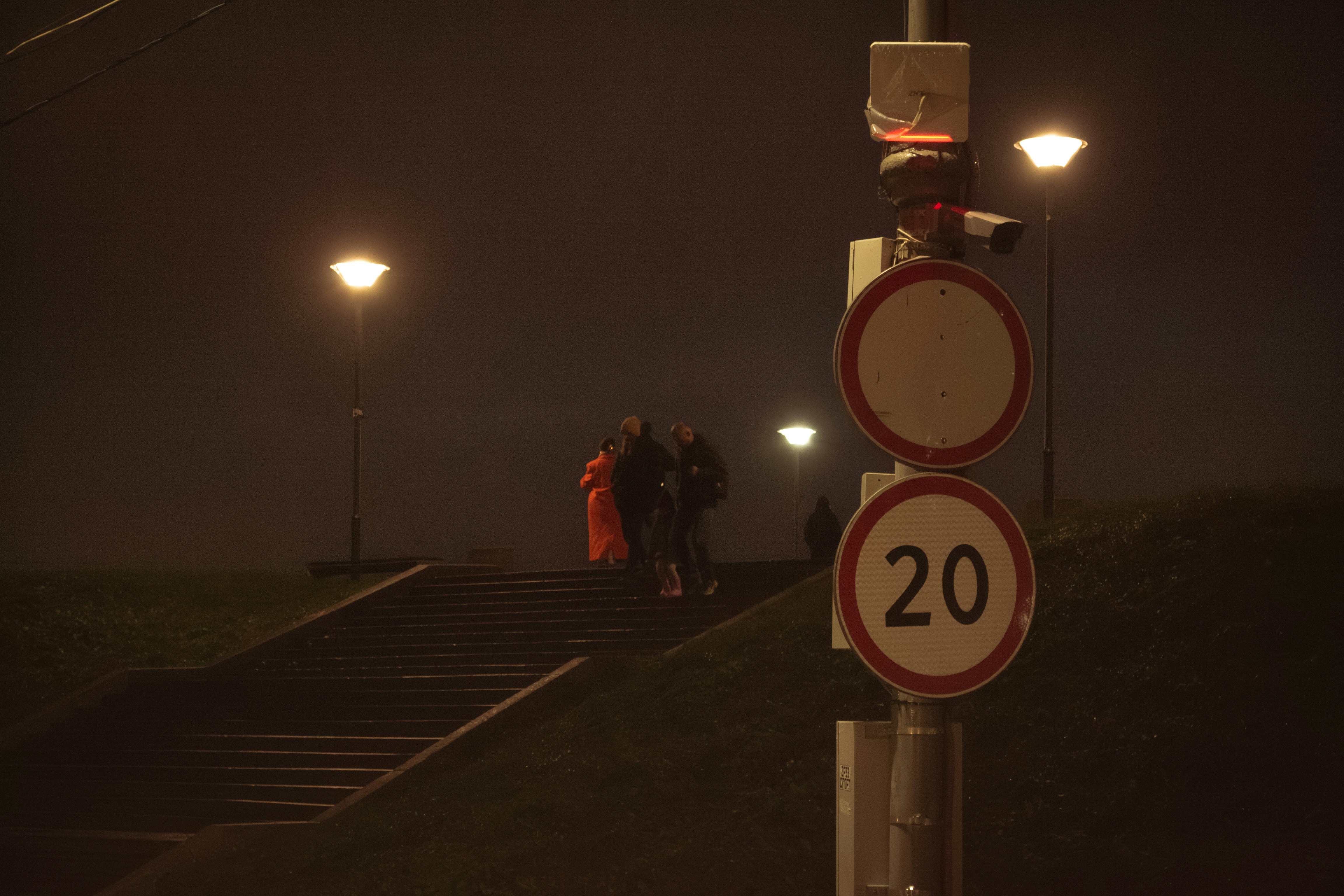 People climb stairs at night with streetlights