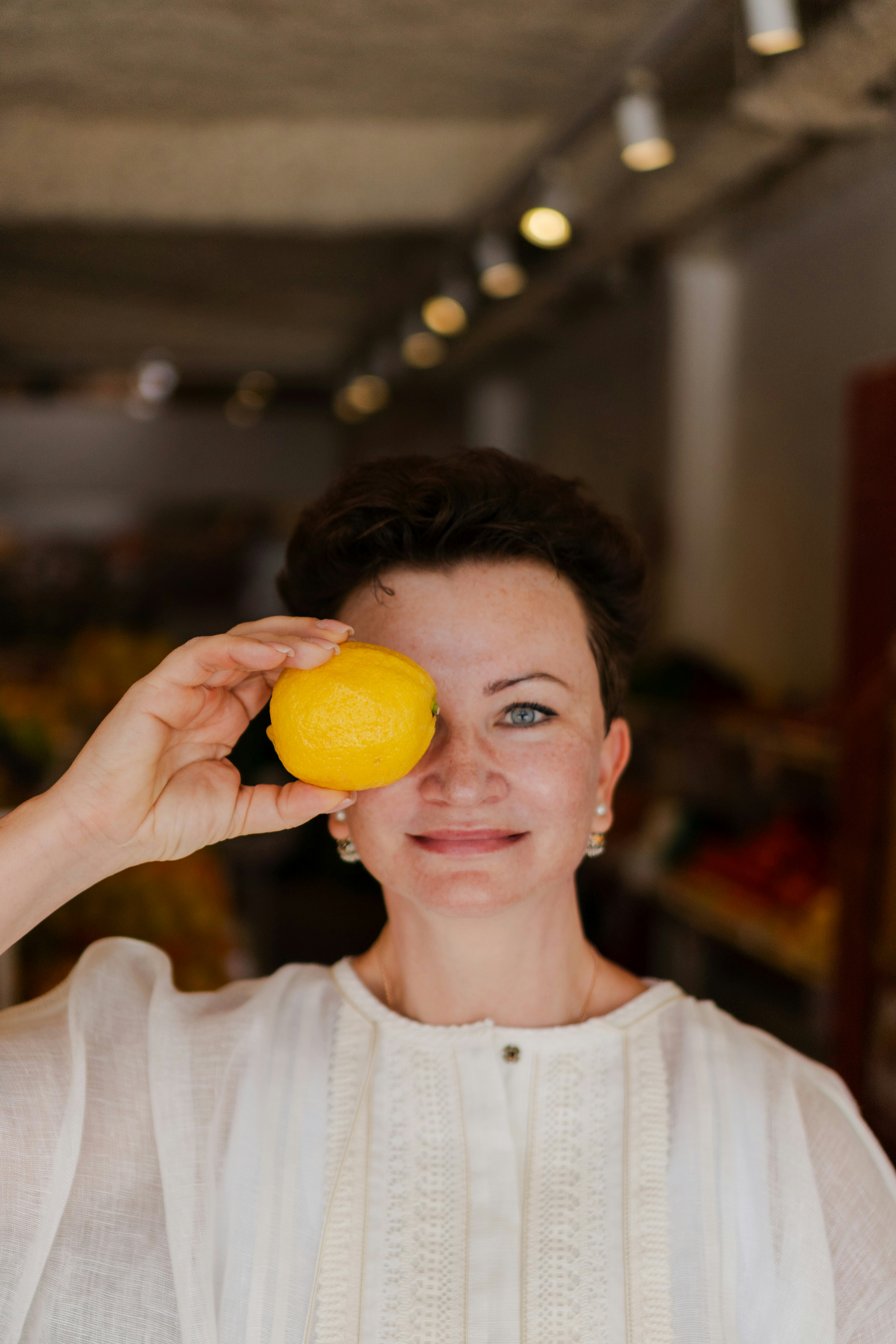 Woman holding a lemon over her eye