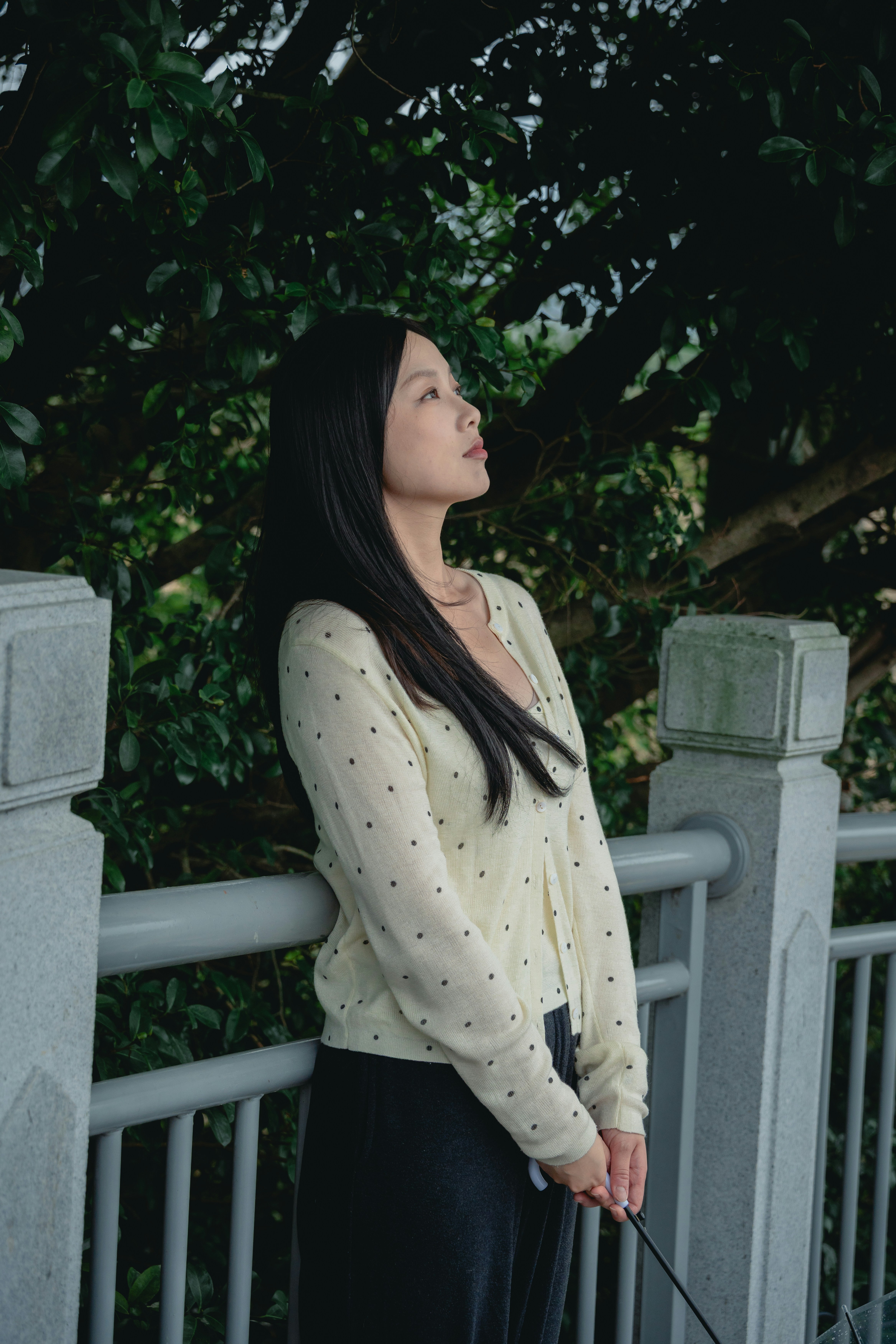 A woman looking up by a railing outdoors