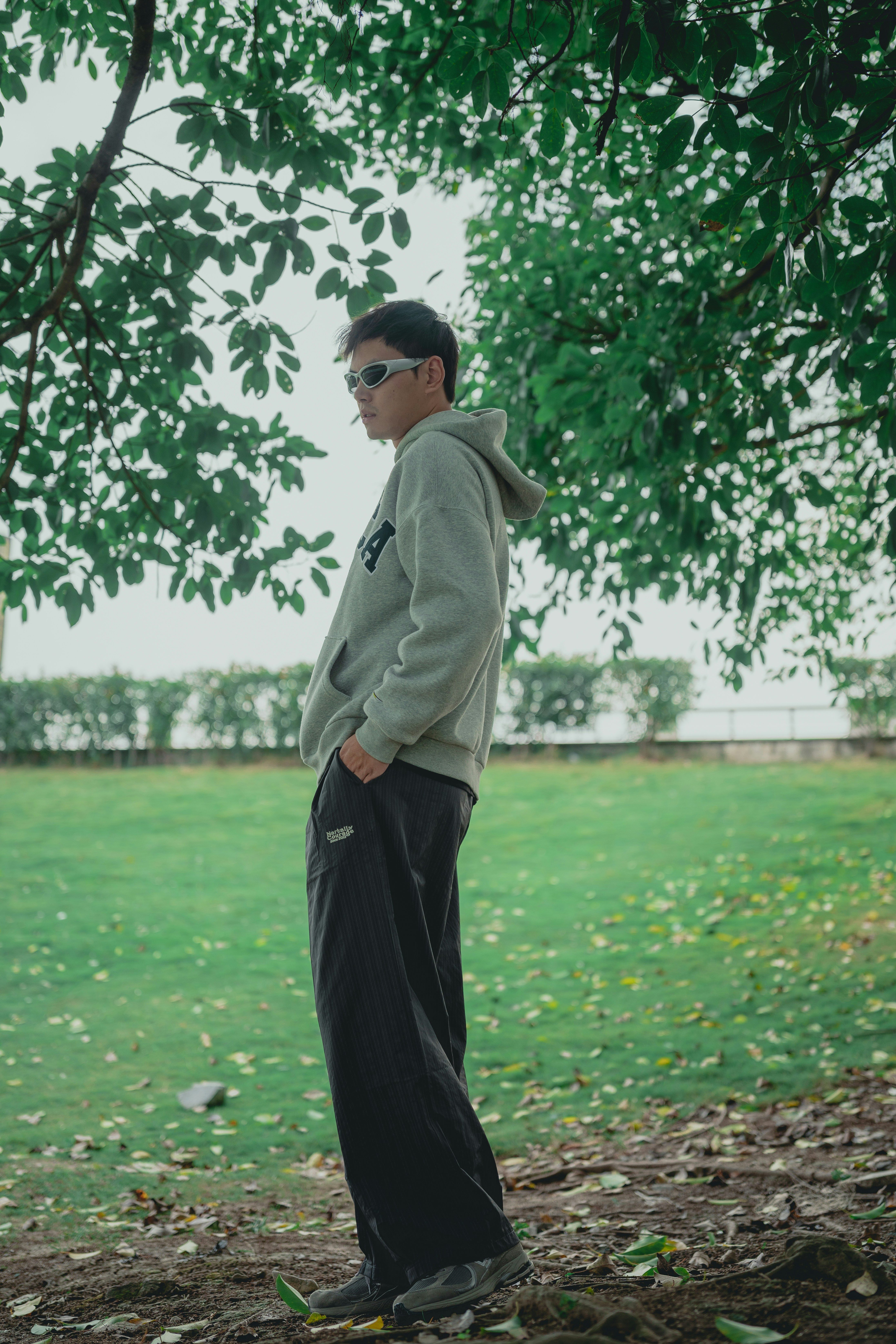 Man wearing sunglasses and hoodie in park