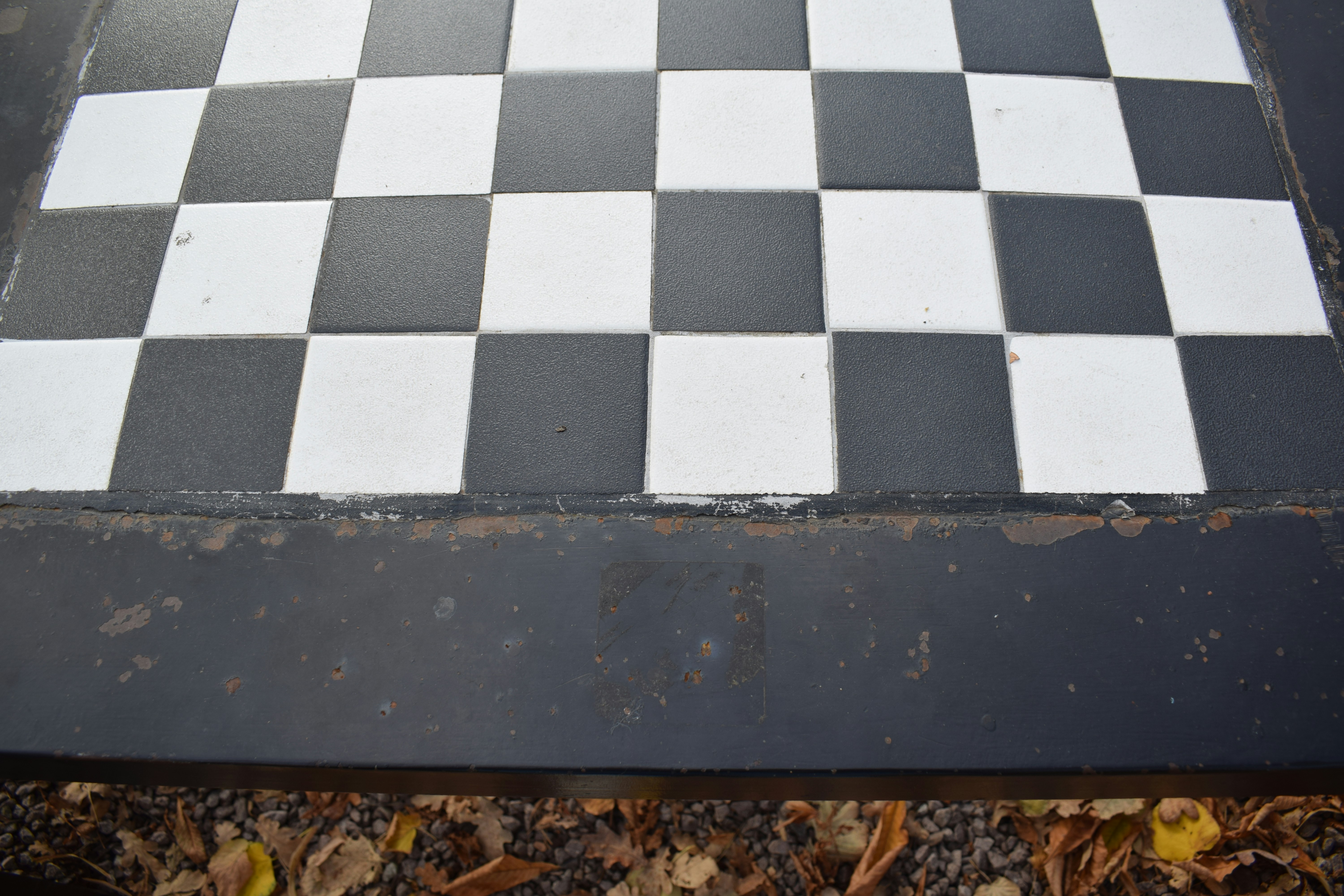 Black and white chessboard pattern with fallen leaves