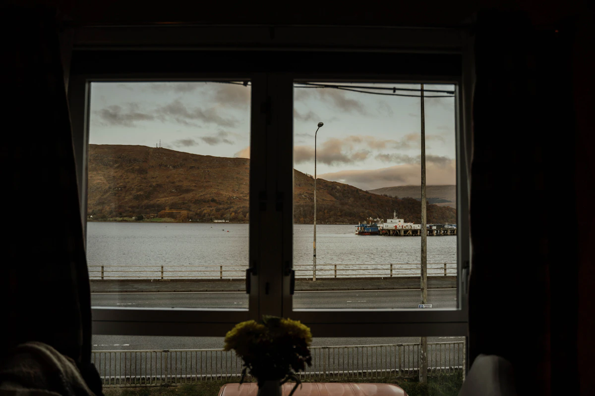 Ferry docked at a pier with cloudy sky.