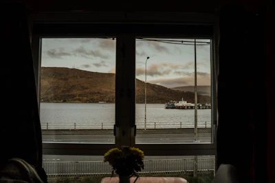 Ferry docked at a pier with cloudy sky.