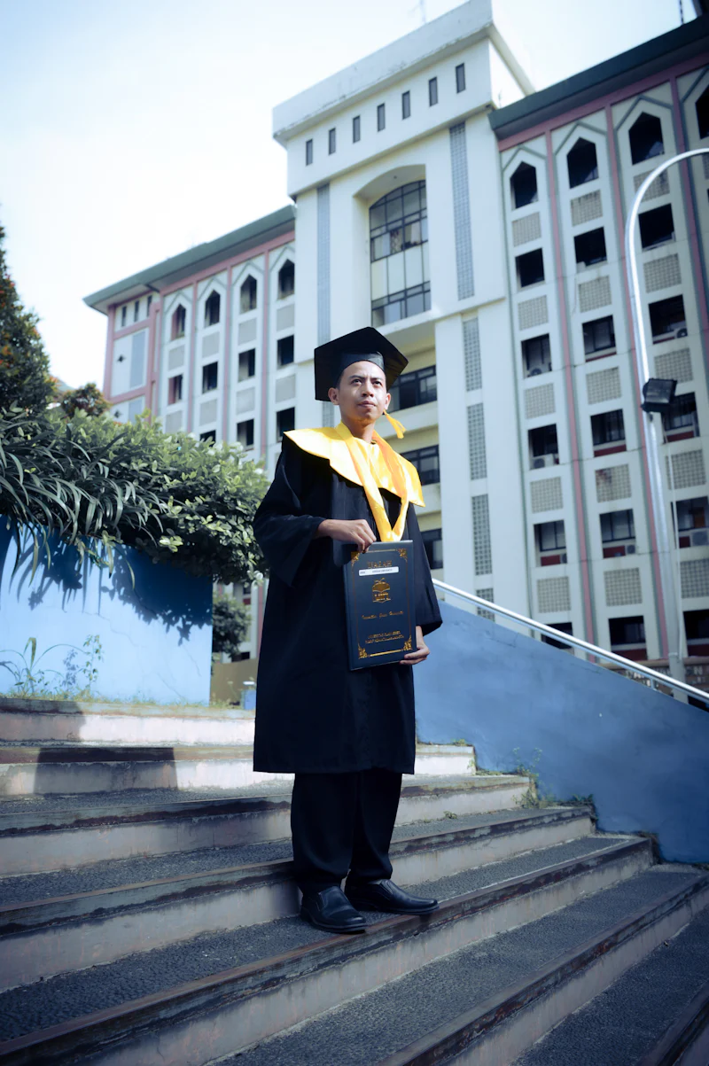 Graduate in cap and gown holding diploma