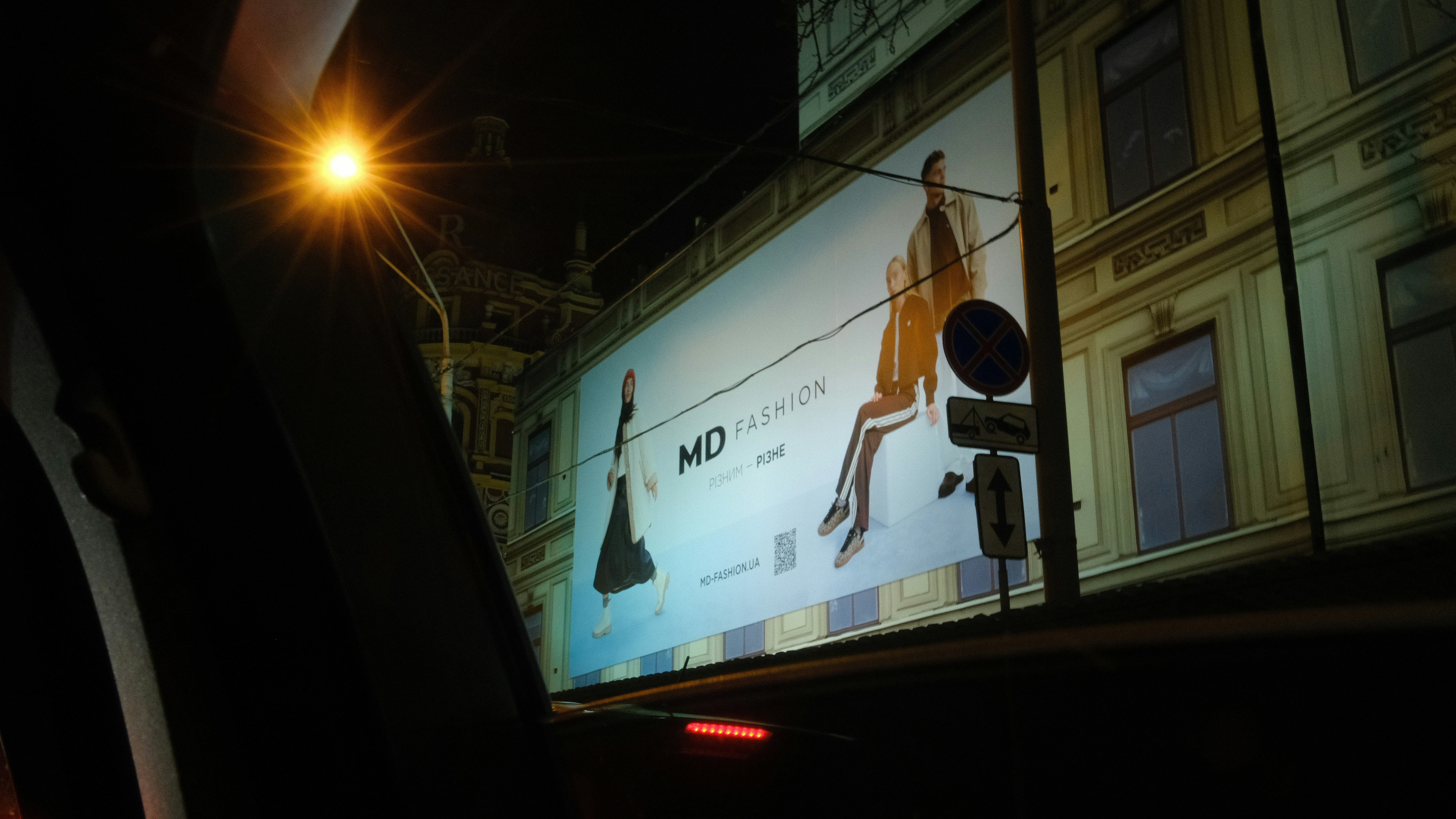 Billboard advertisement on a building at night.