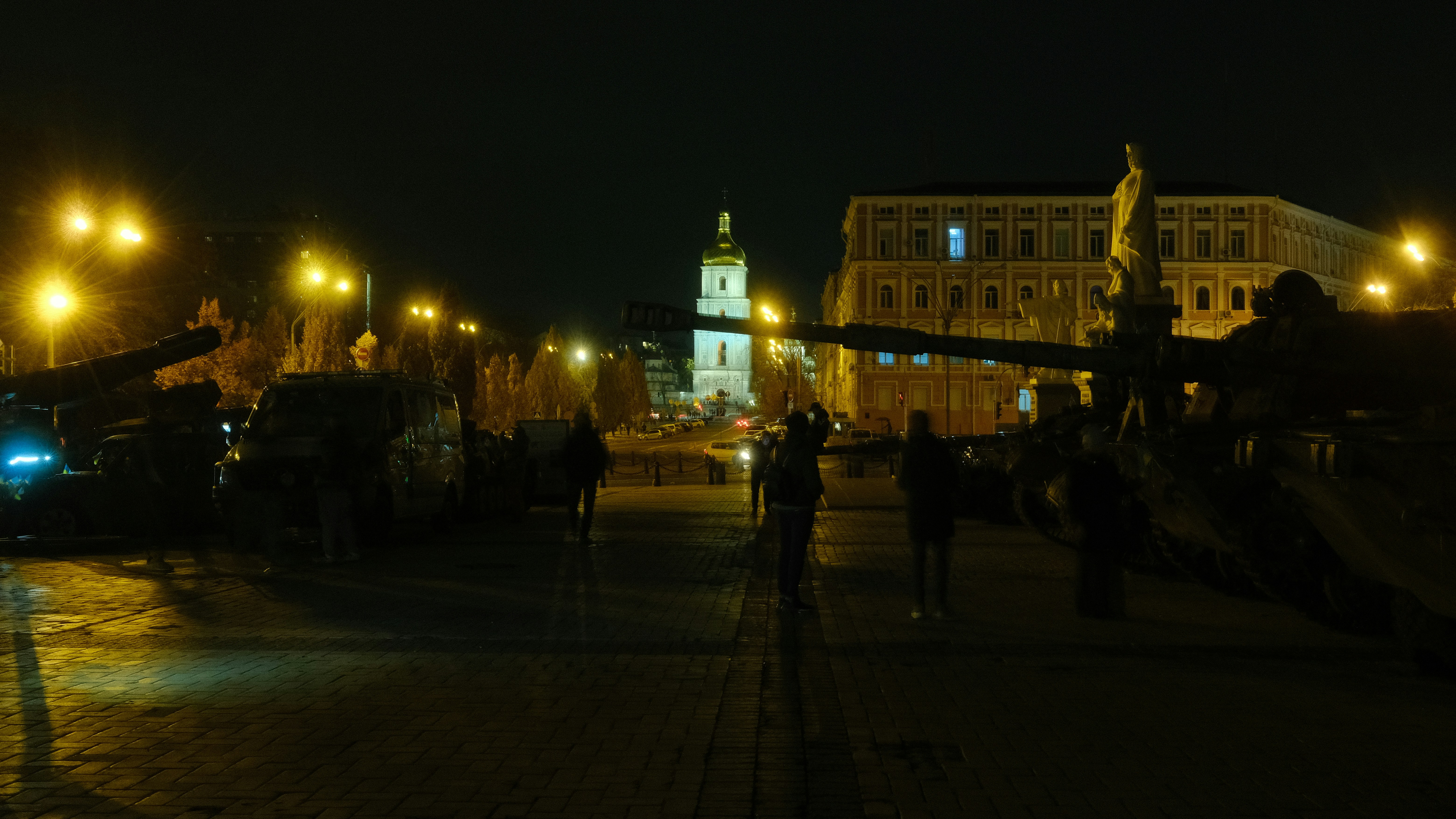 ライトアップされた建物と人々がいる夜の街の広場。