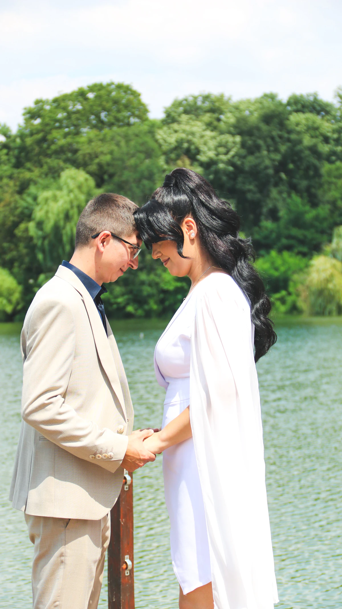 Couple foreheads touching by lake — restored closeness
