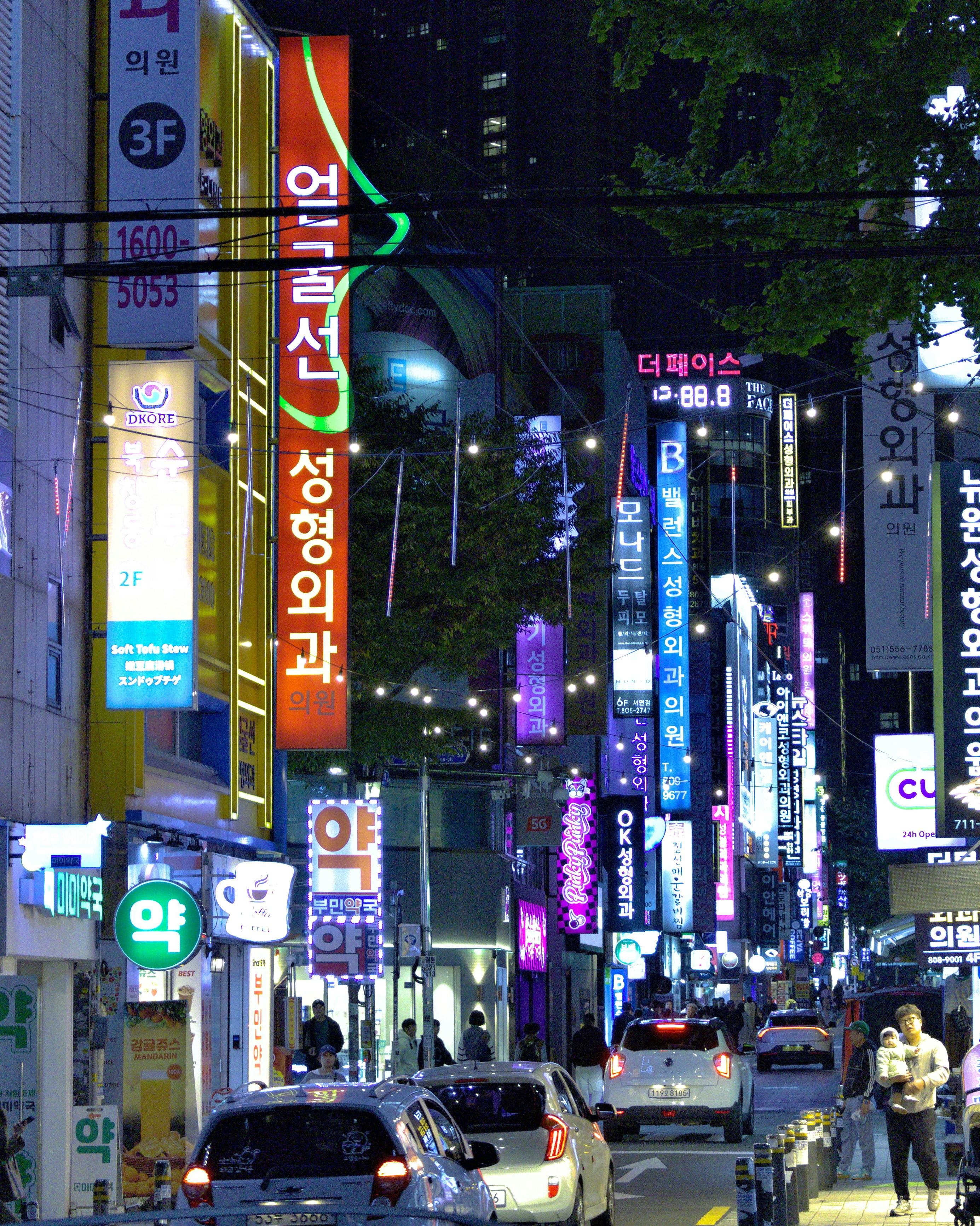 Street at night with many illuminated signs.