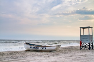 Boat and lifeguard stand on a sandy beach.