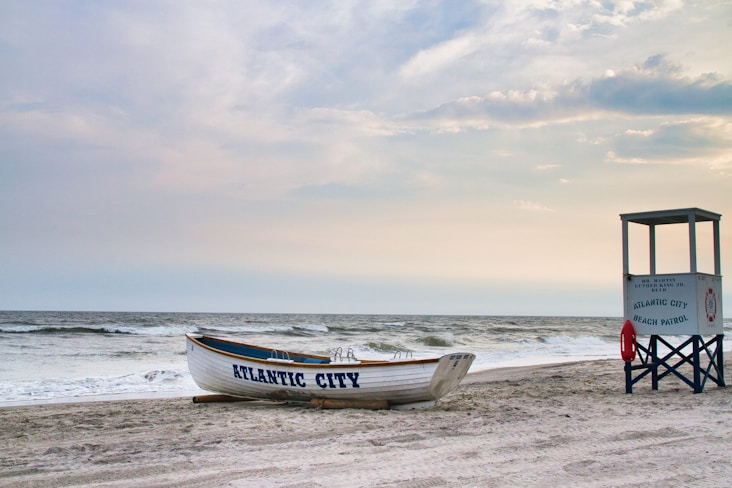 Boat and lifeguard stand on a sandy beach.