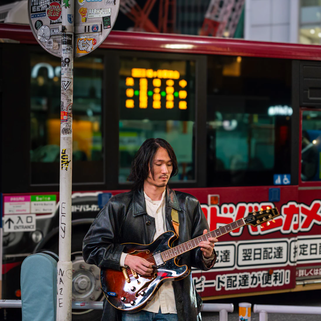 Street musician playing electric guitar in the city at night