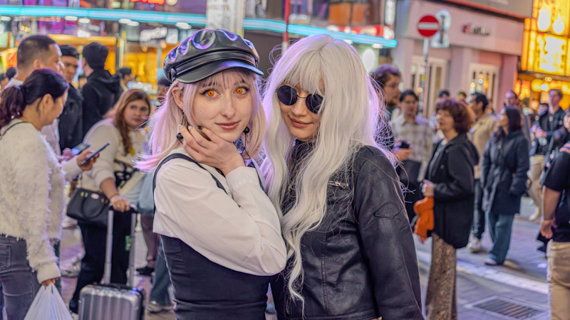 Two women with white hair on a busy street.