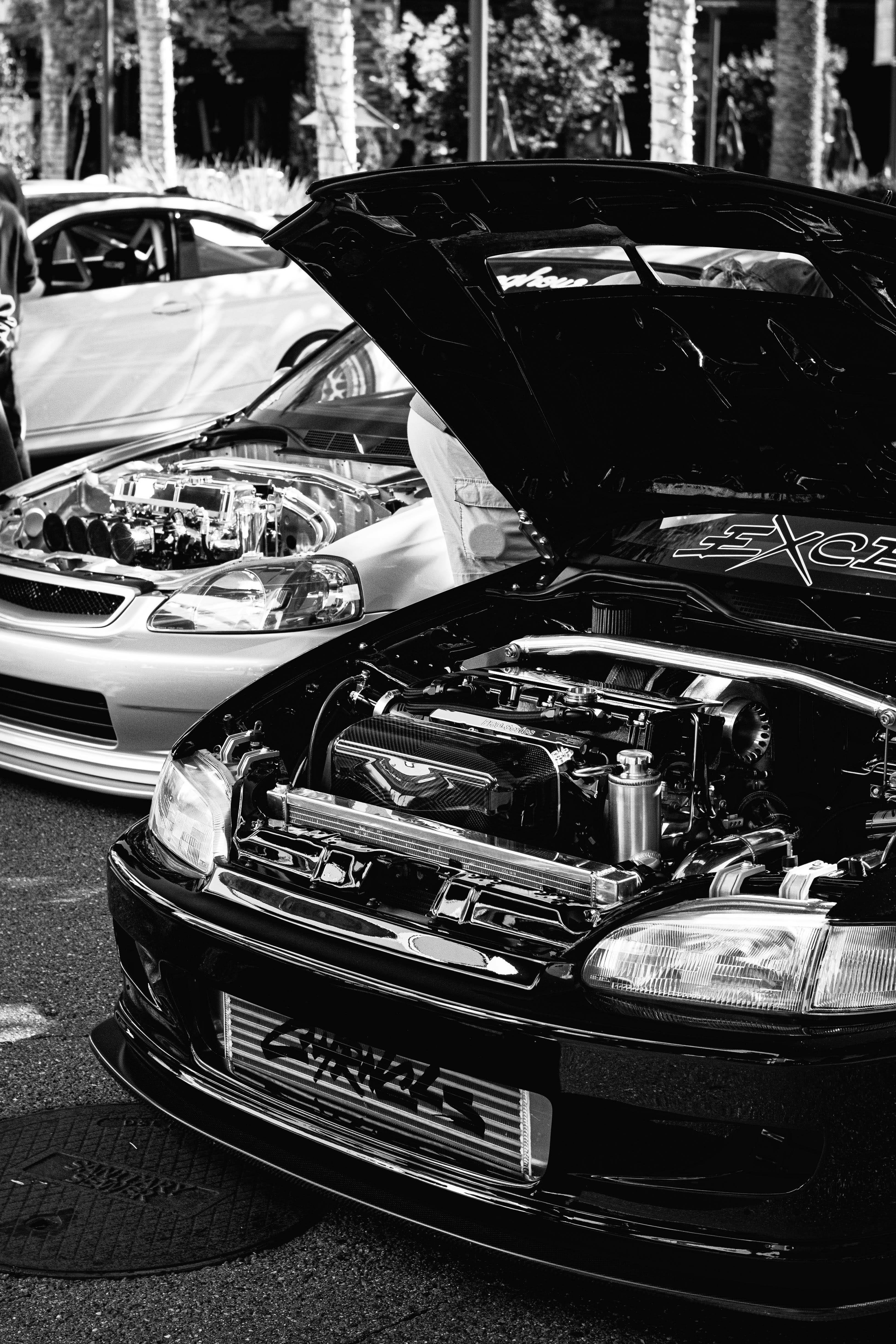 Deux voitures avec les capots ouverts montrant les moteurs