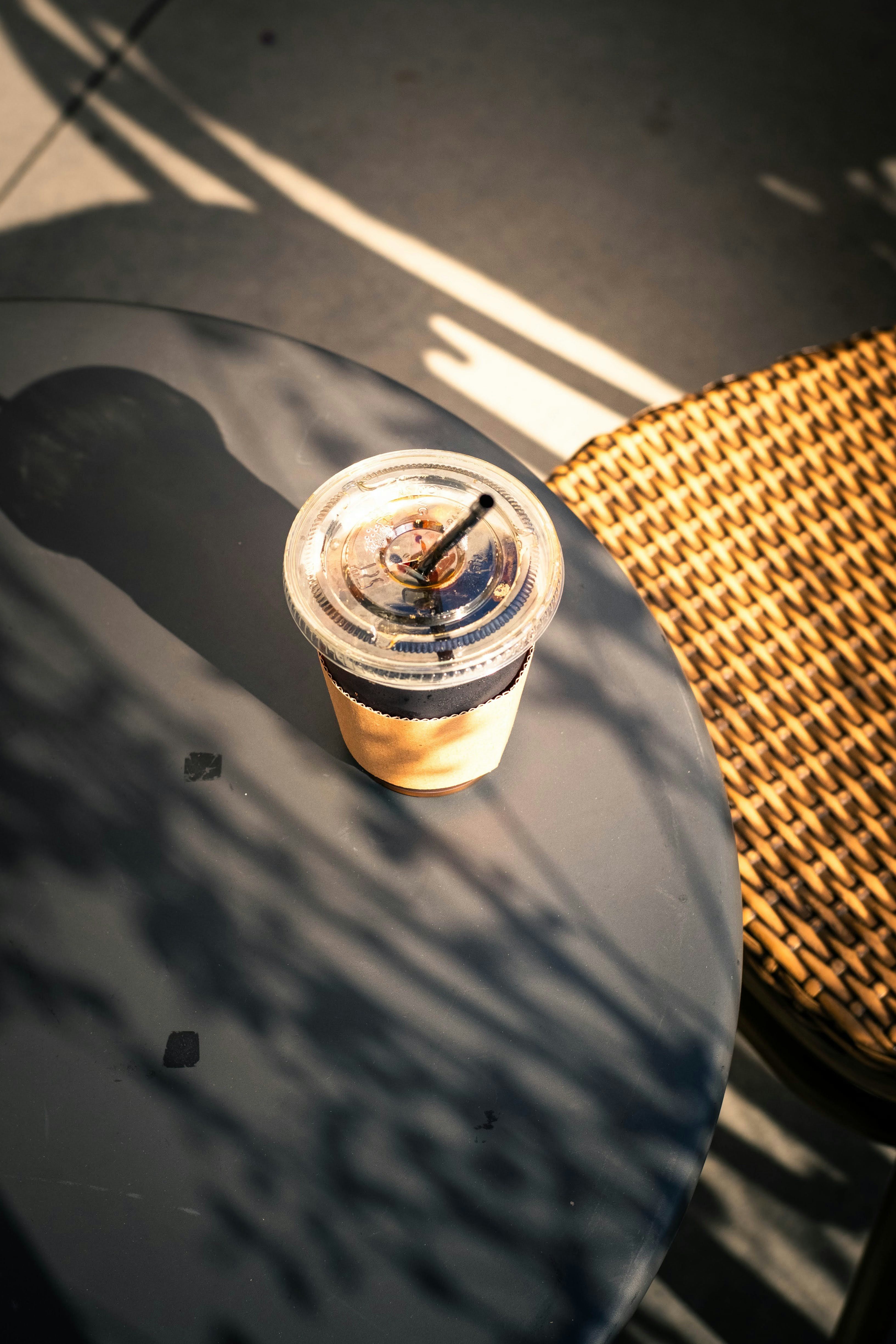 Iced coffee on a table with dappled sunlight