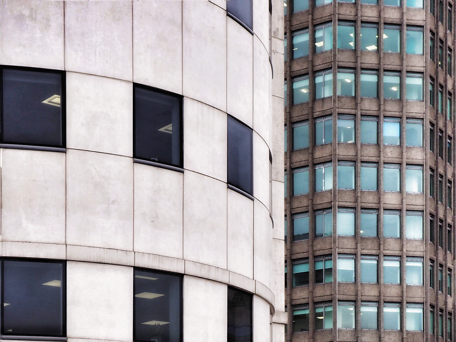 Contrasting curved facades and windows of city office buildings.