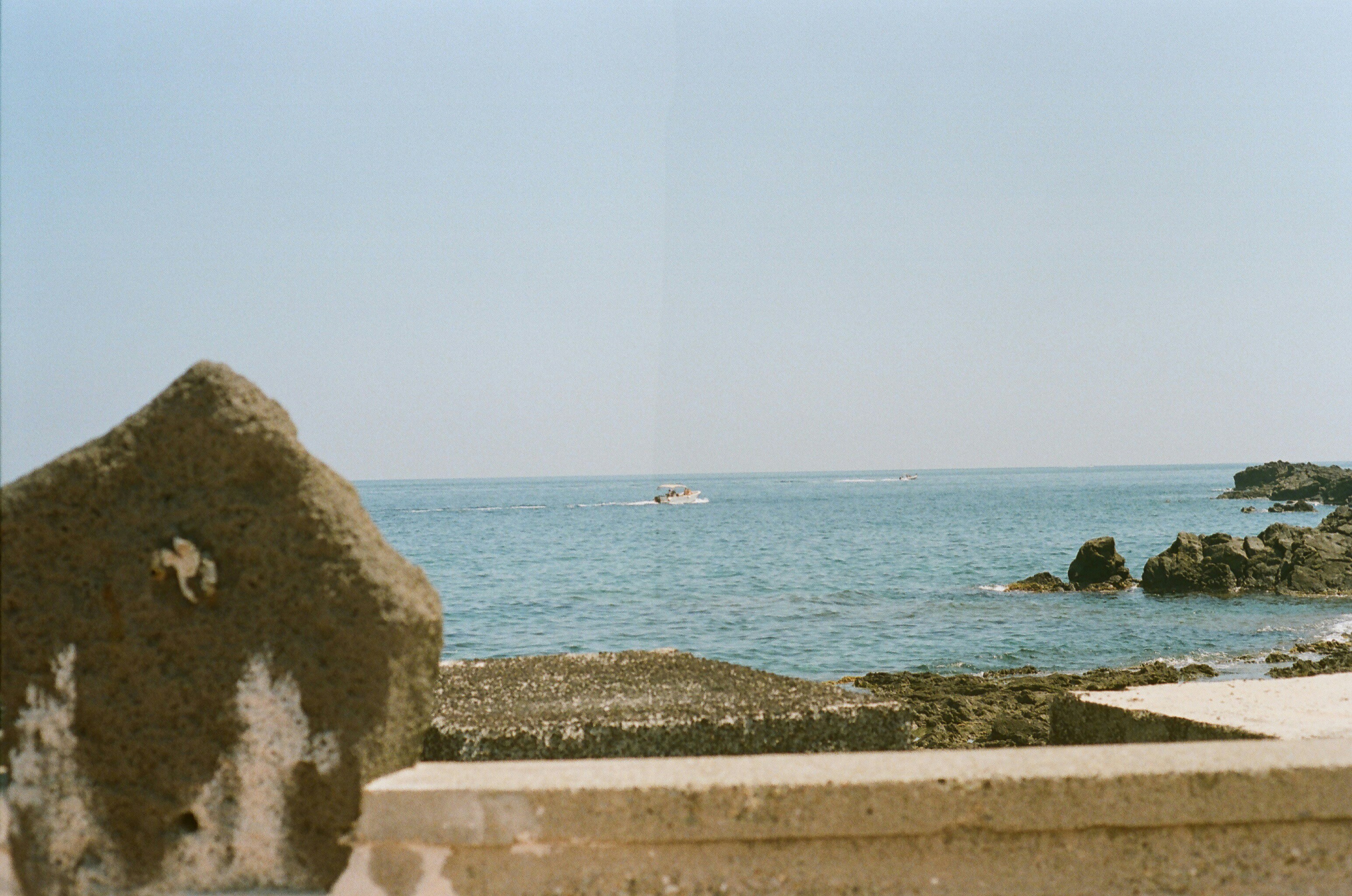 Boat on the ocean near rocky shore