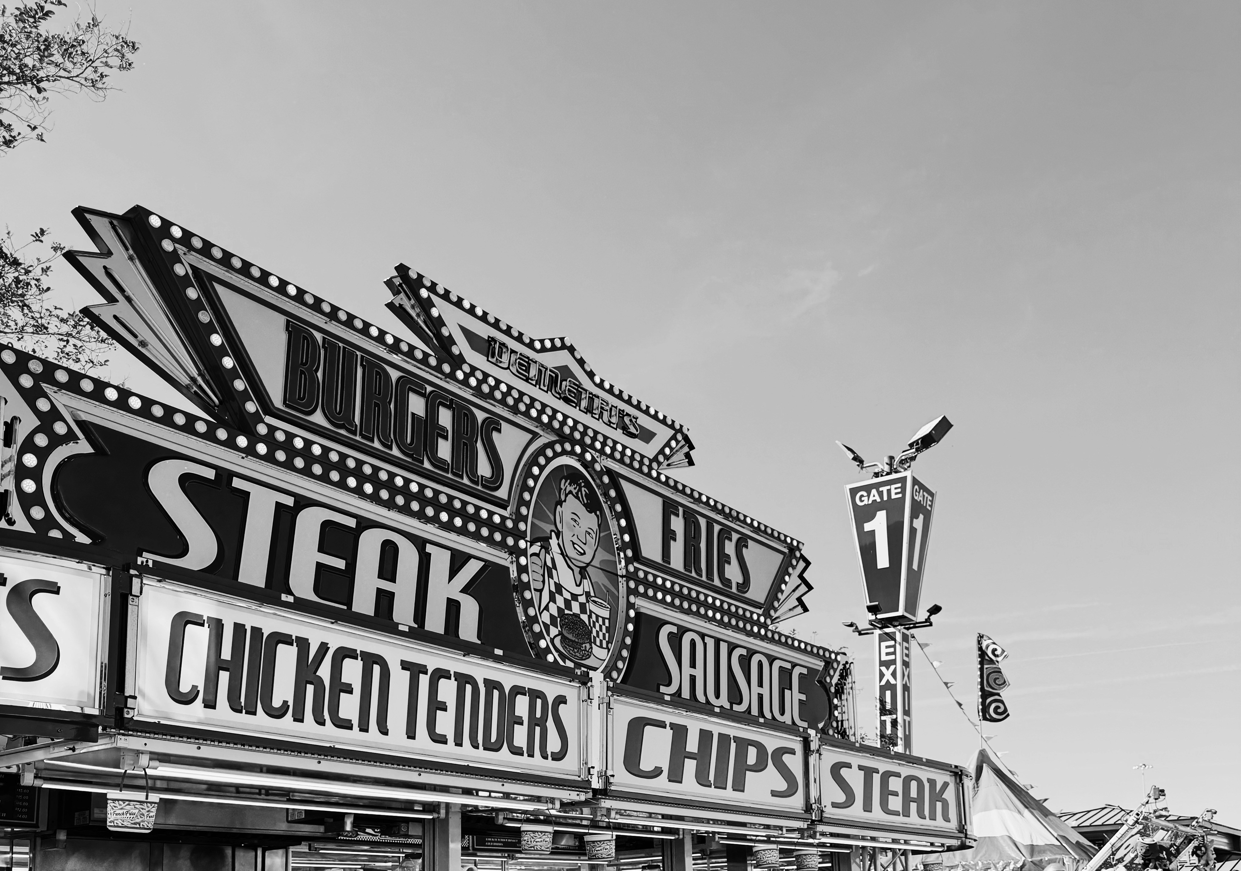 Carnival food stand sign with burgers and fries.