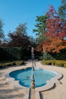 A formal garden with a fountain and statues.