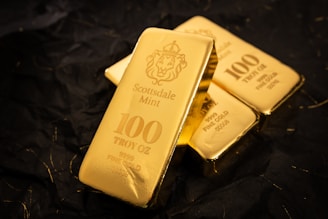 Several gold bars stacked on a dark surface