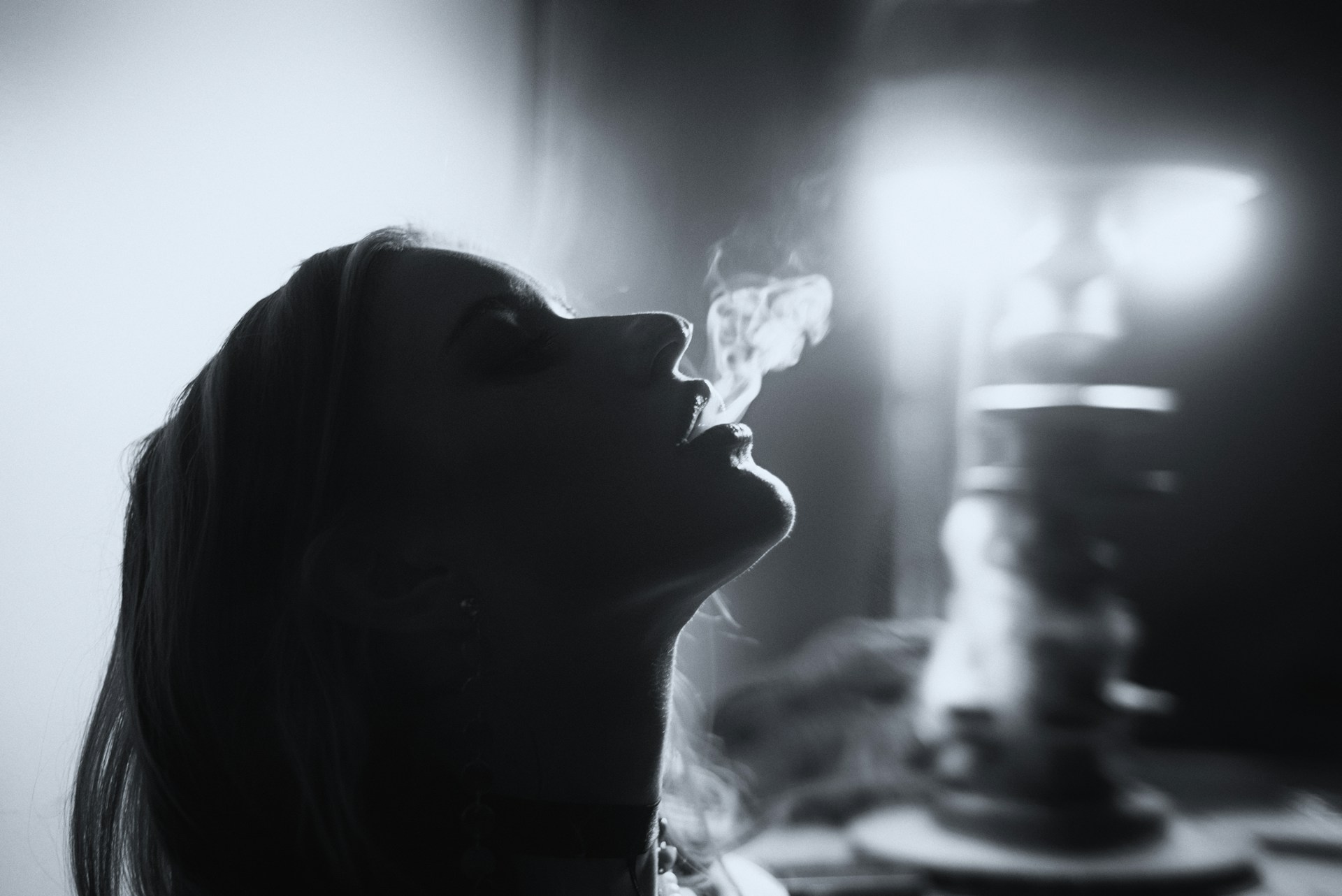 Woman exhaling smoke from a hookah