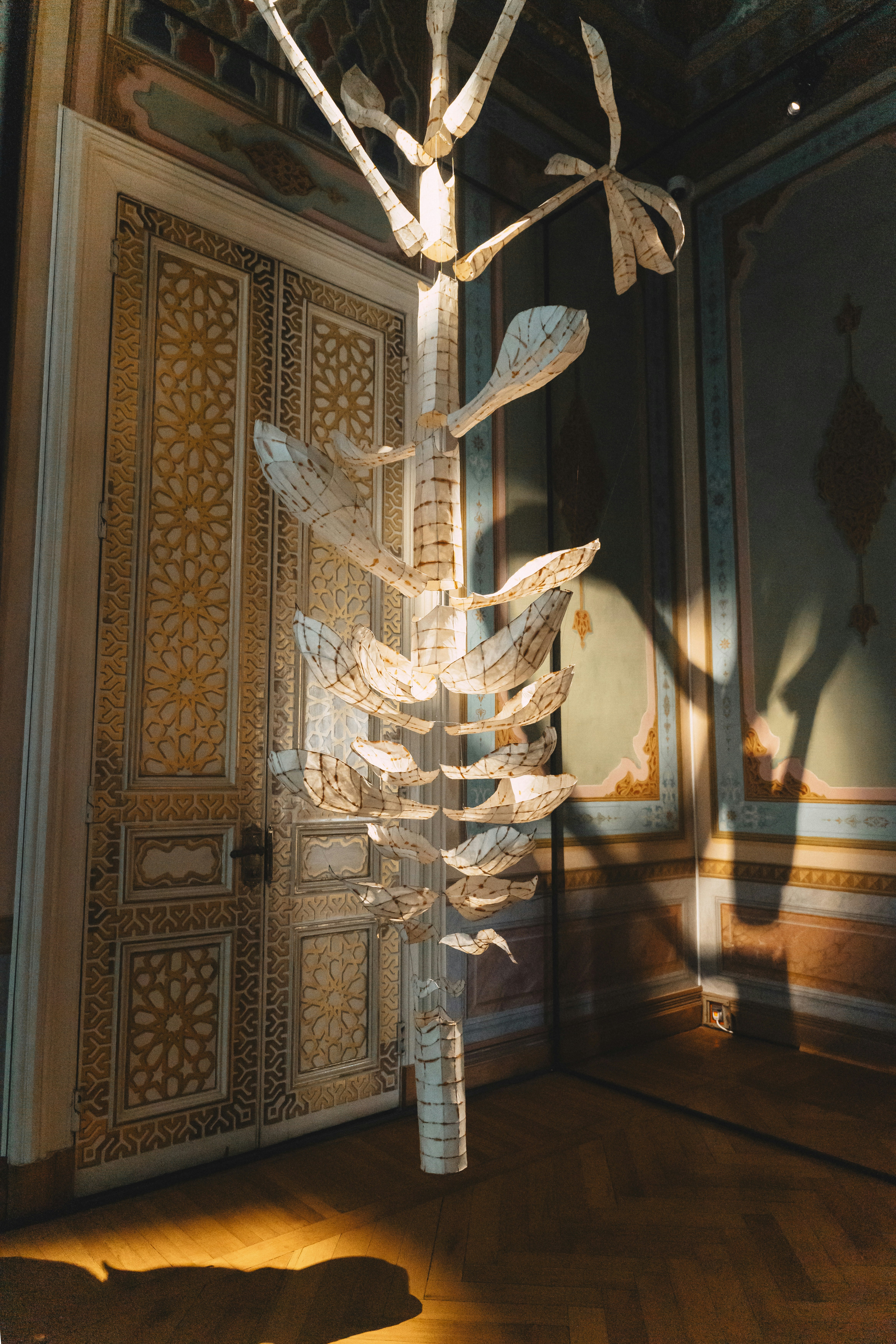 Una puerta ornamentada con una escultura de papel colgante.