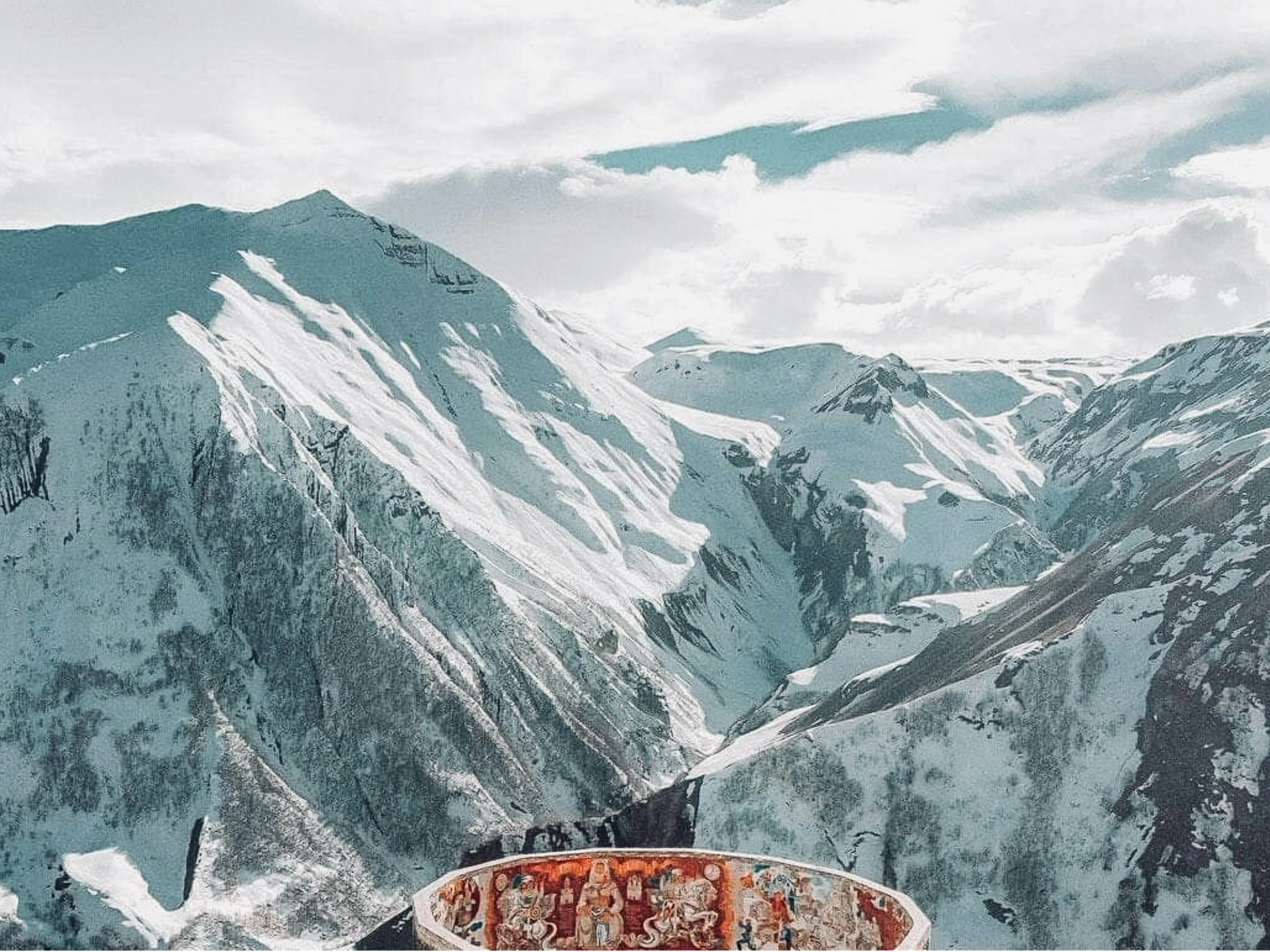 Snow-covered mountains under a cloudy sky