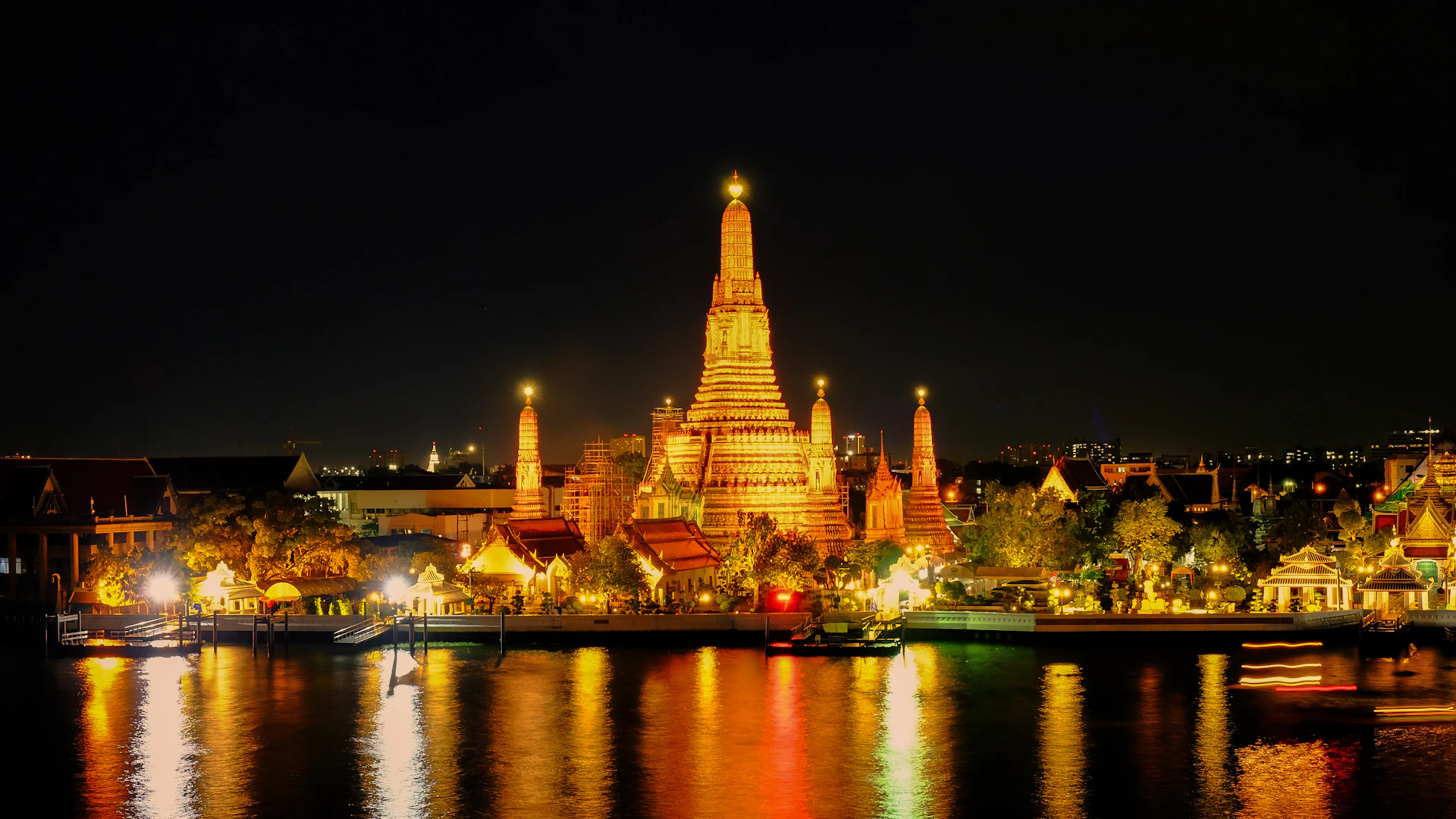 Temple illuminated at night with river reflections
